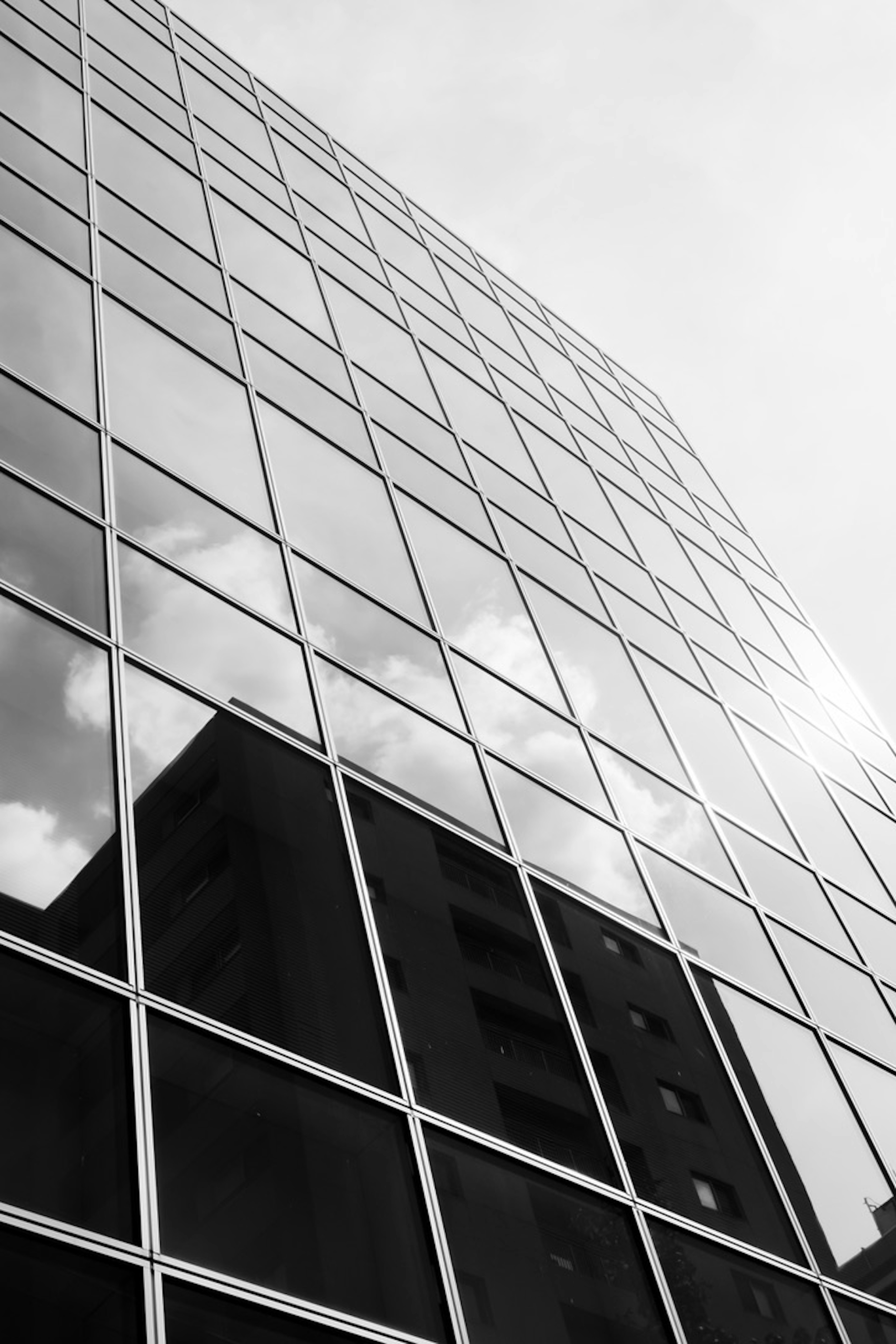 Fachada de un edificio de vidrio que refleja nubes