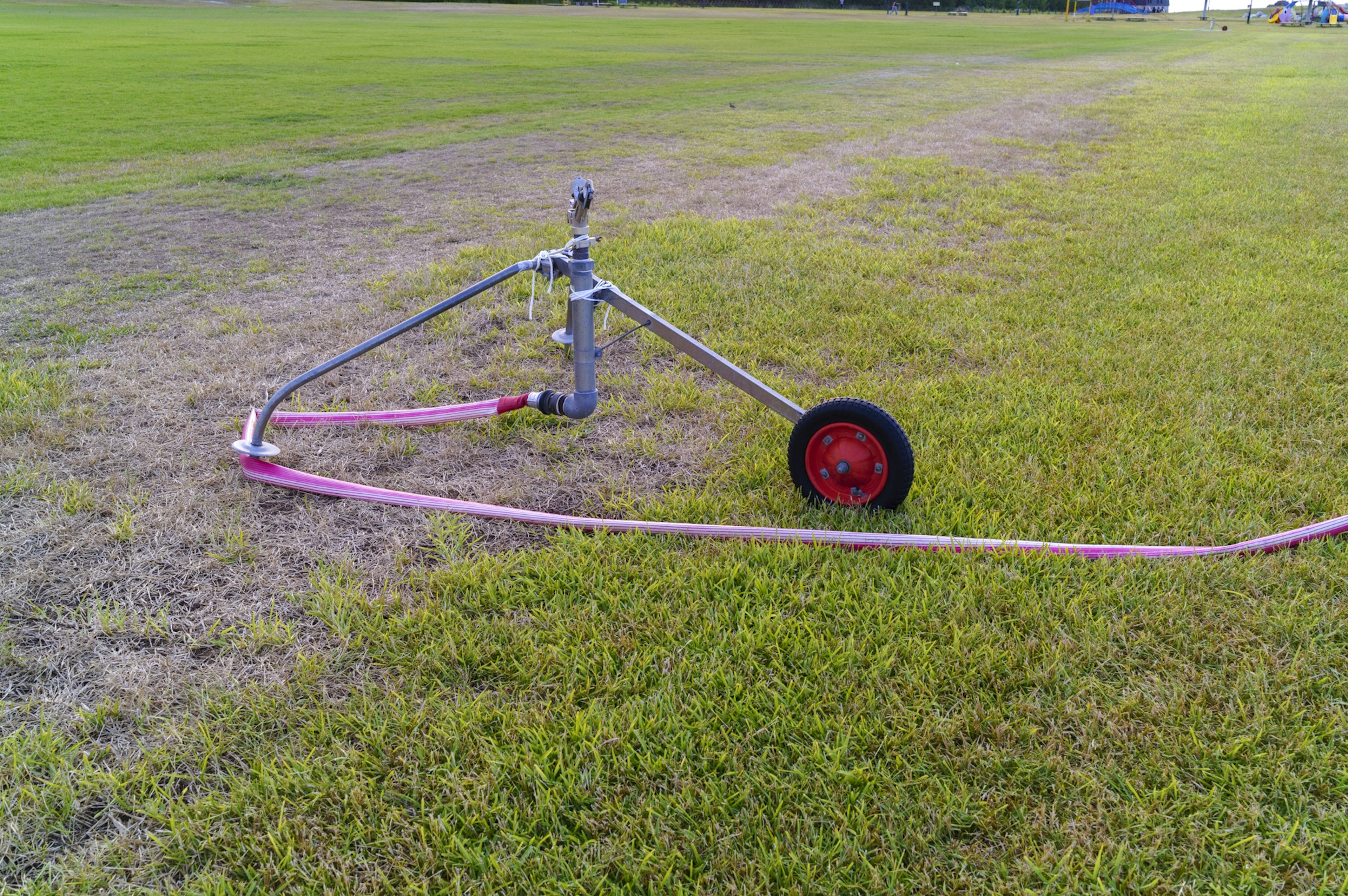 Irrigation sprinkler with a wheel on grass