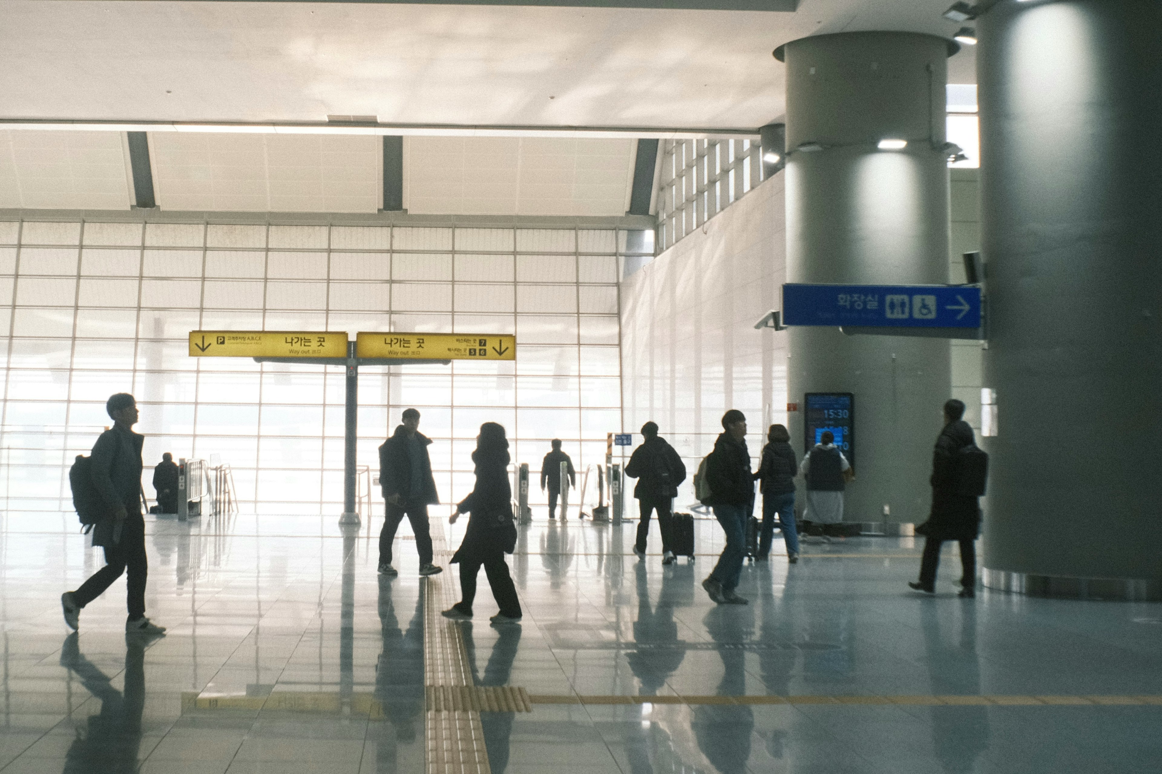 공항 터미널에서 걷고 있는 사람들의 실루엣