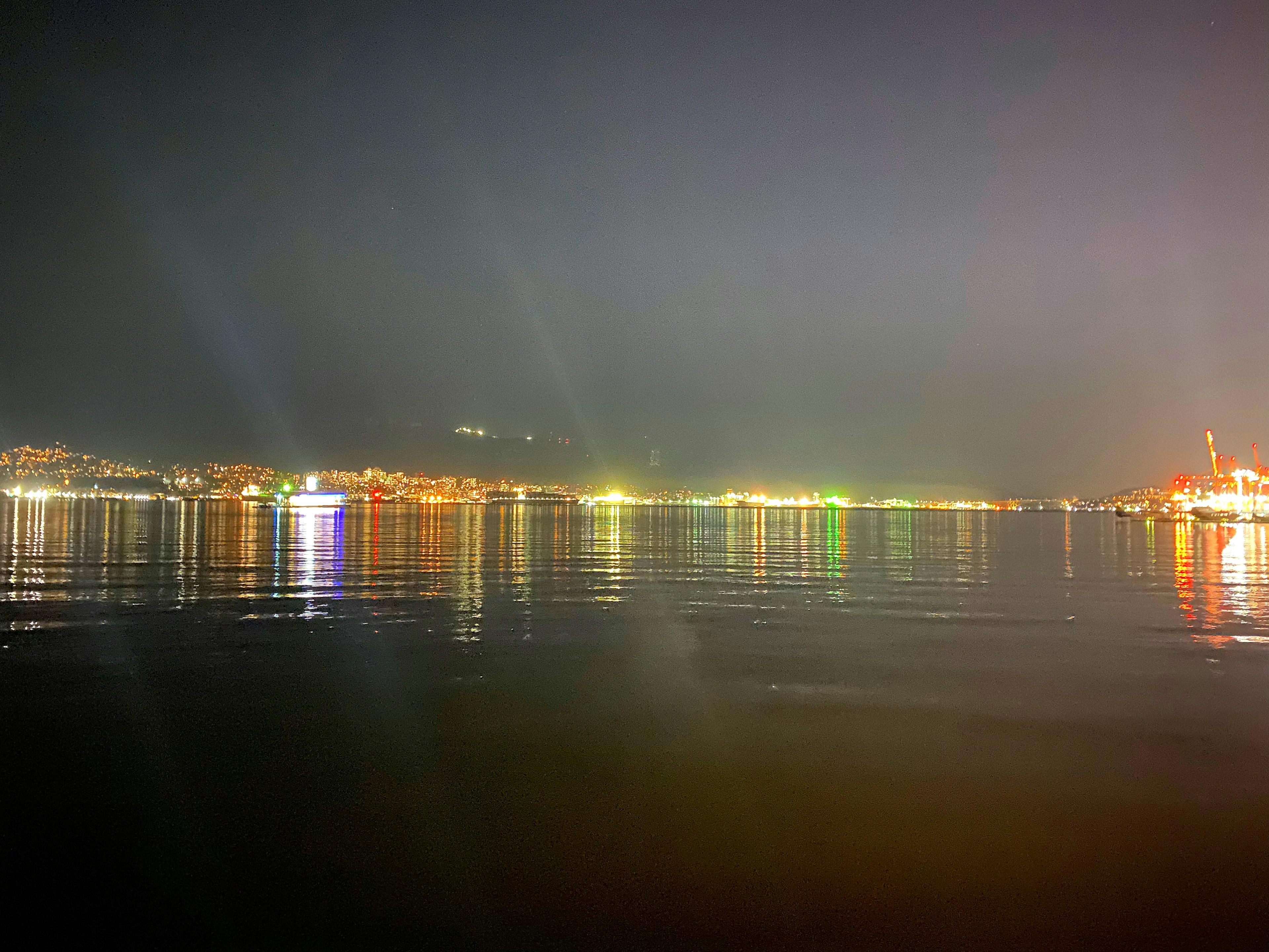 Reflejos de luces coloridas en el agua de noche