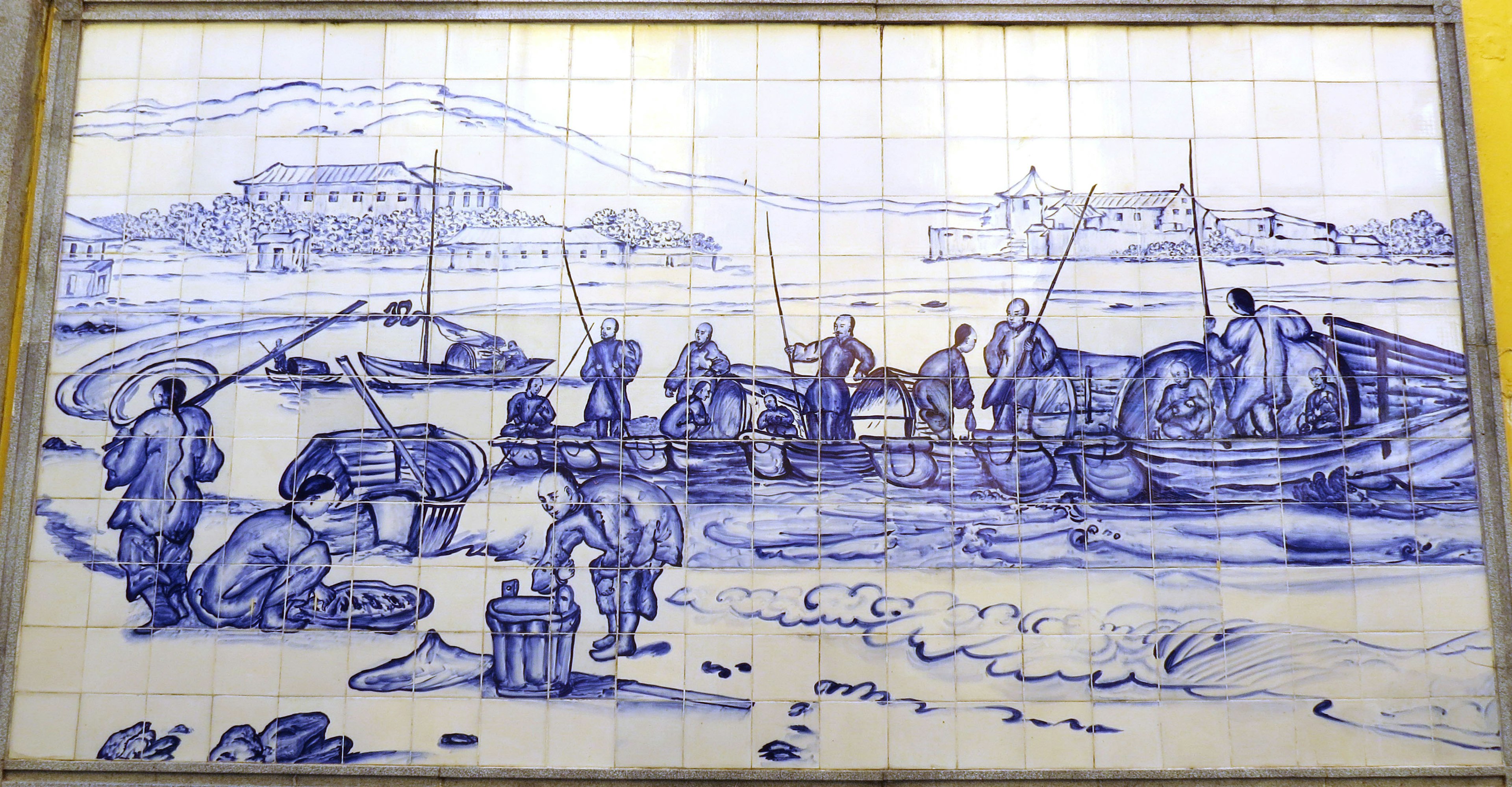 Blue tile mural depicting fishermen working on the shore and in boats