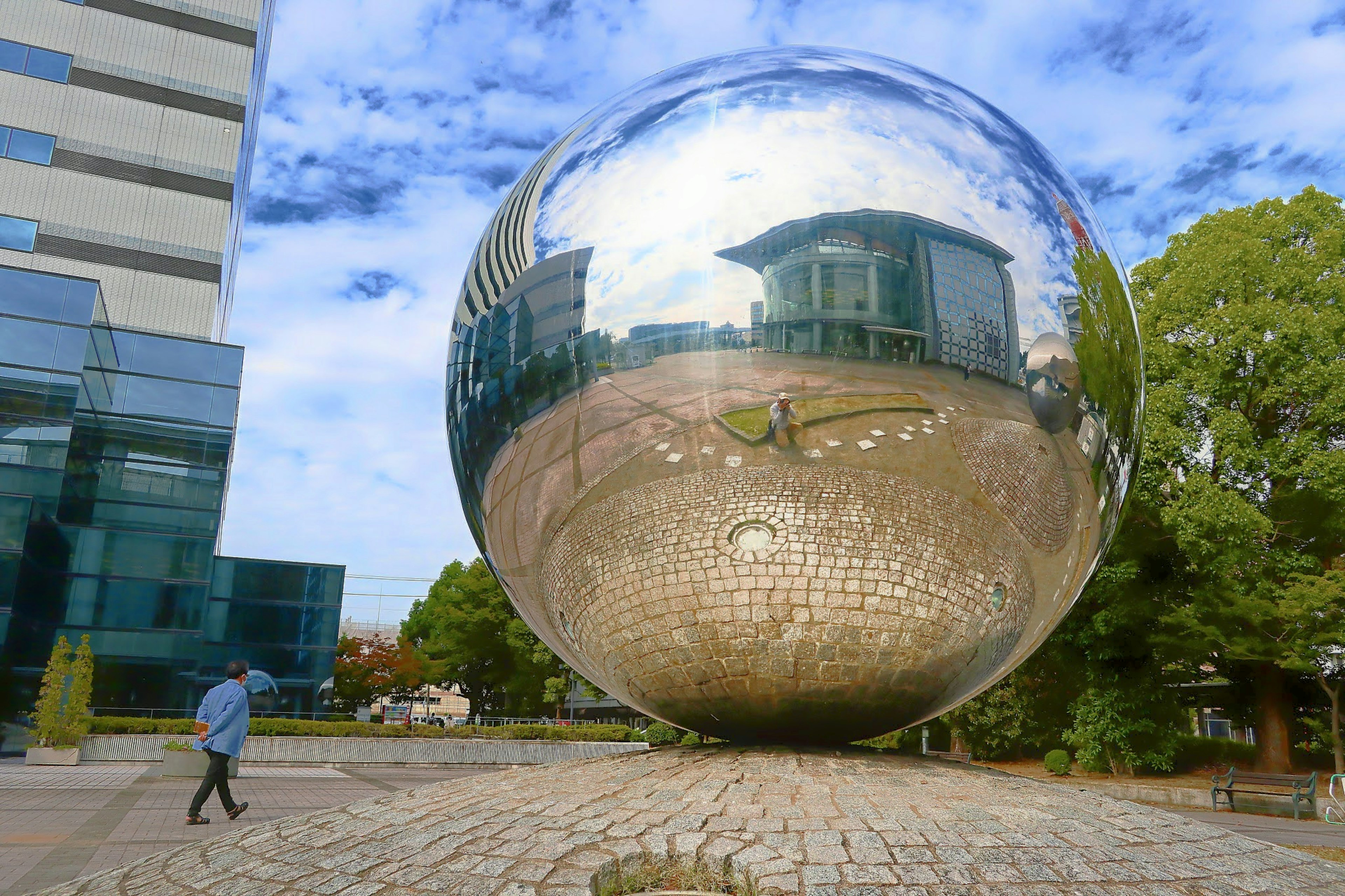 Grande sphère réfléchissante devant un bâtiment