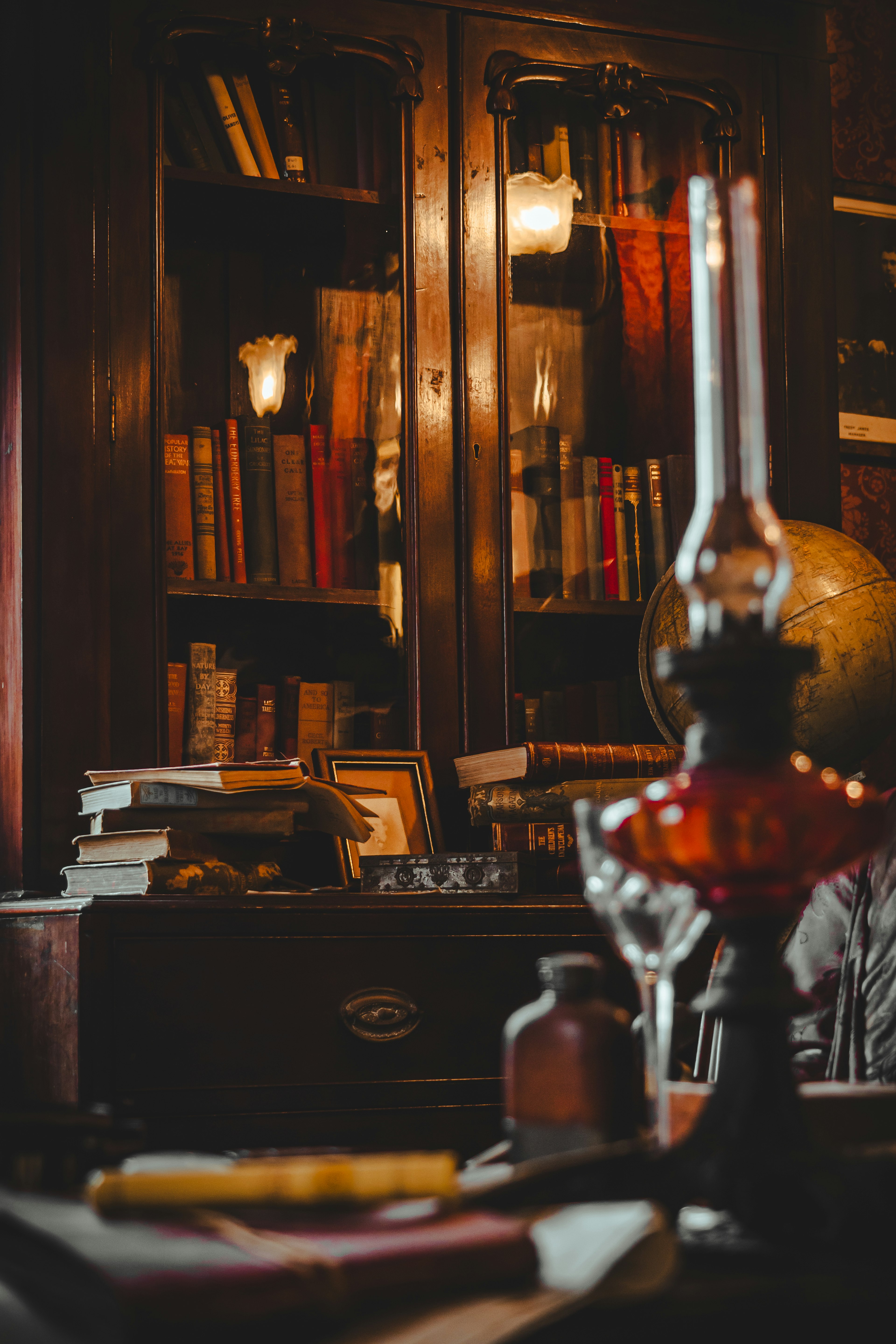 Interior cálido con una estantería de libros antiguos y una lámpara de aceite