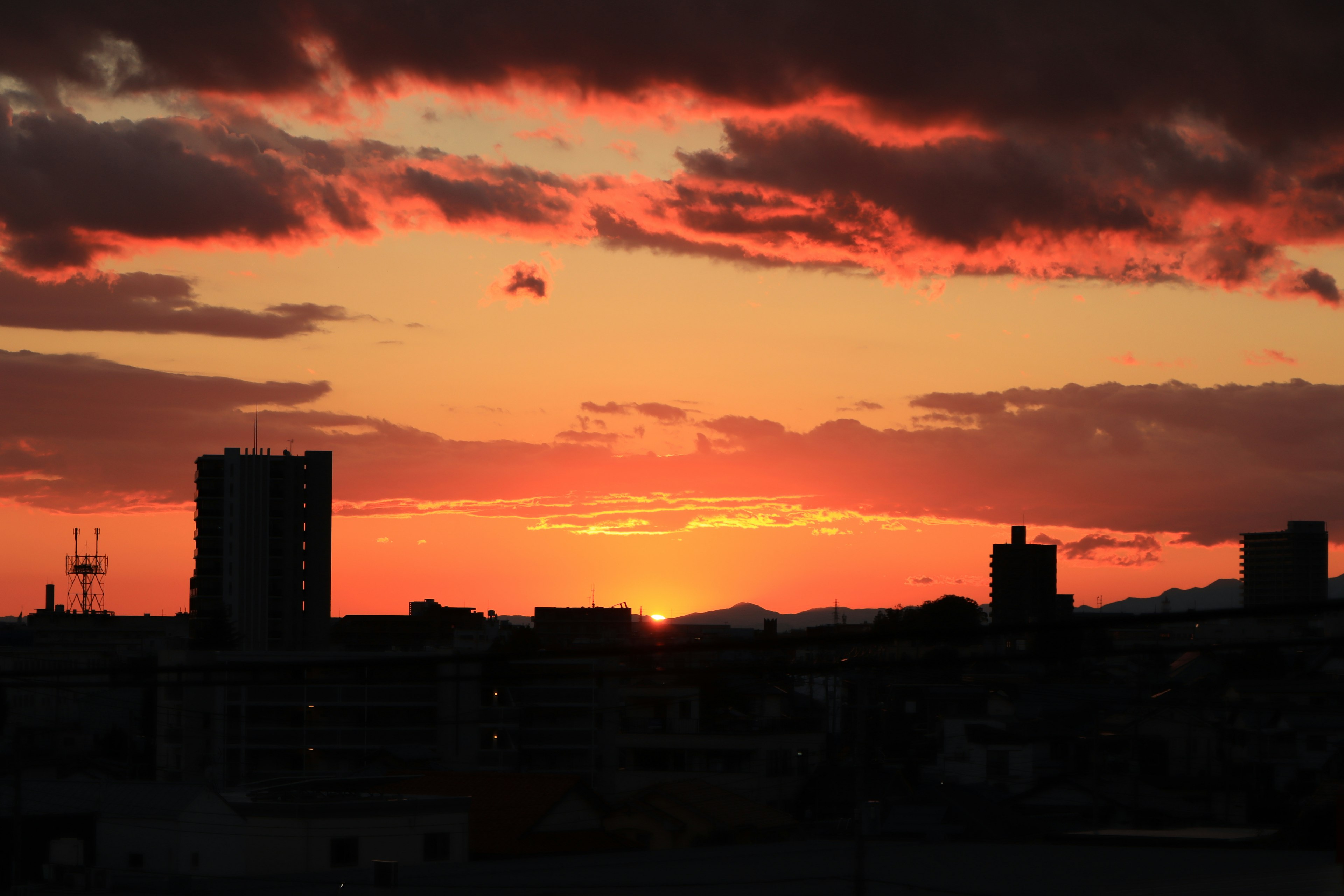 Silhouette von Gebäuden vor einem lebhaften Sonnenuntergangshimmel