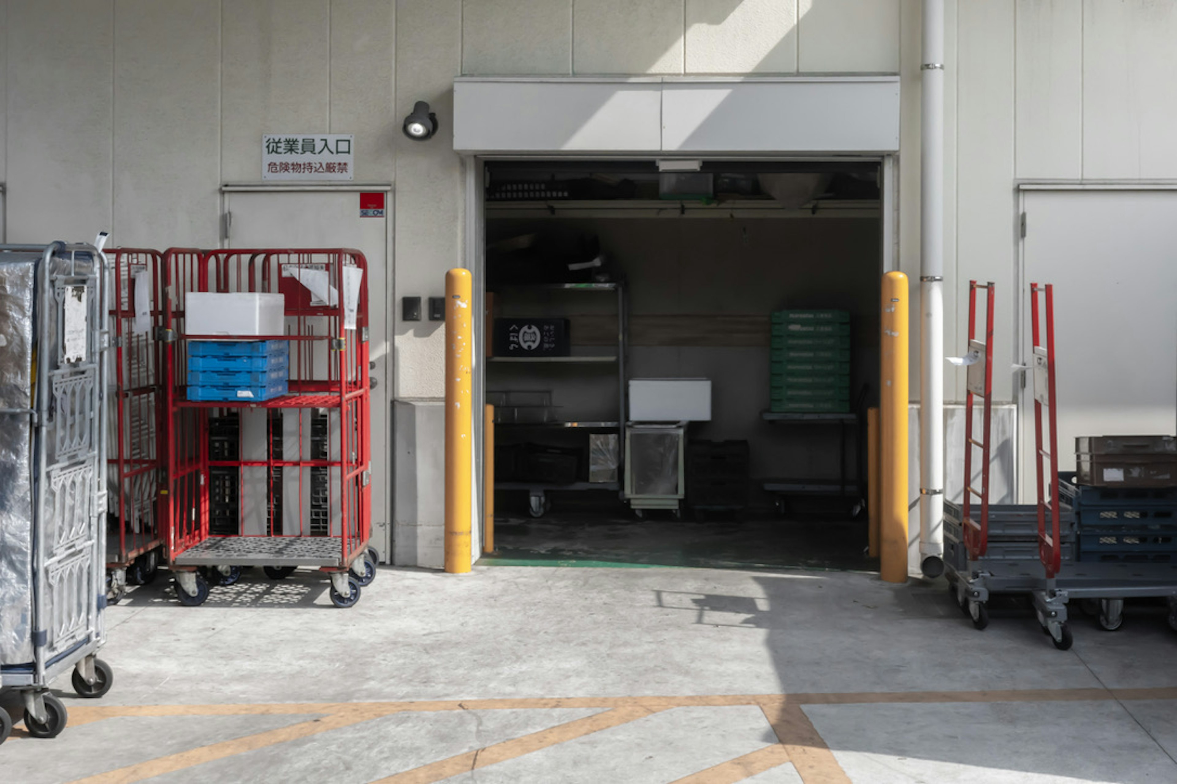 Warehouse entrance with red carts lined up outside