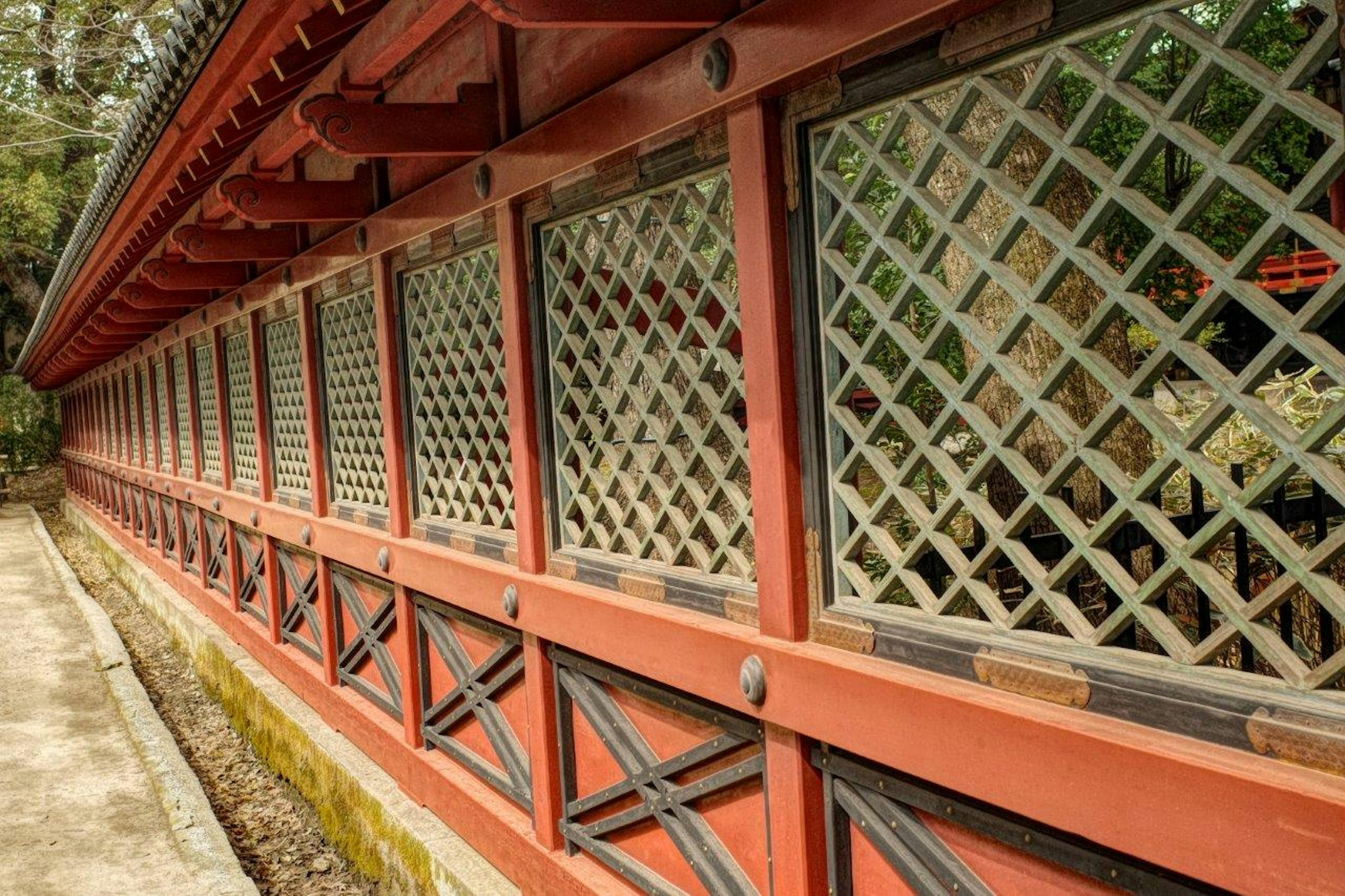 Section of a traditional Japanese building featuring a red wooden wall with lattice windows