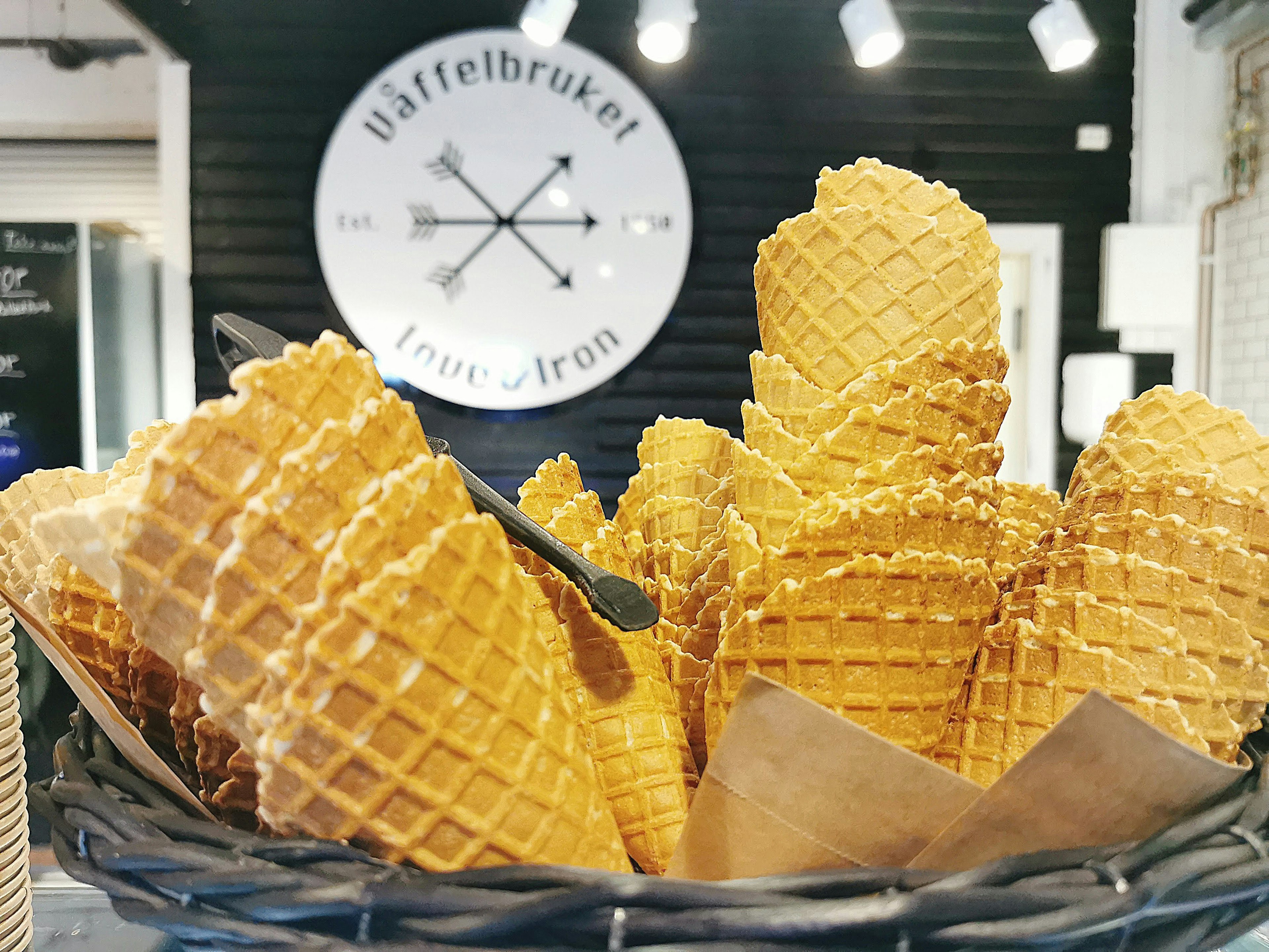 Una cesta llena de conos de galleta para helado con un fondo elegante