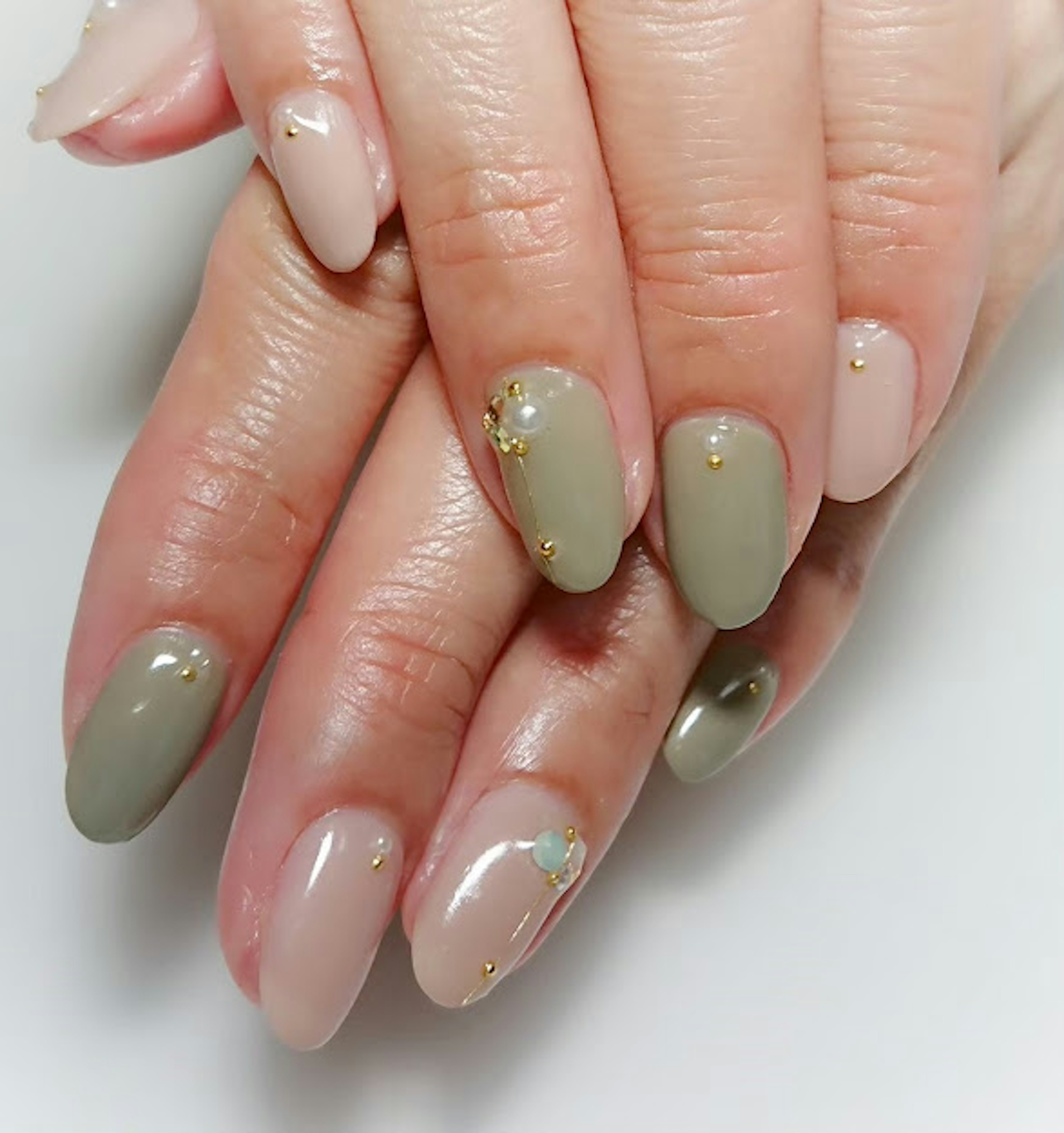 Imagen de manos con arte de uñas en verde y beige