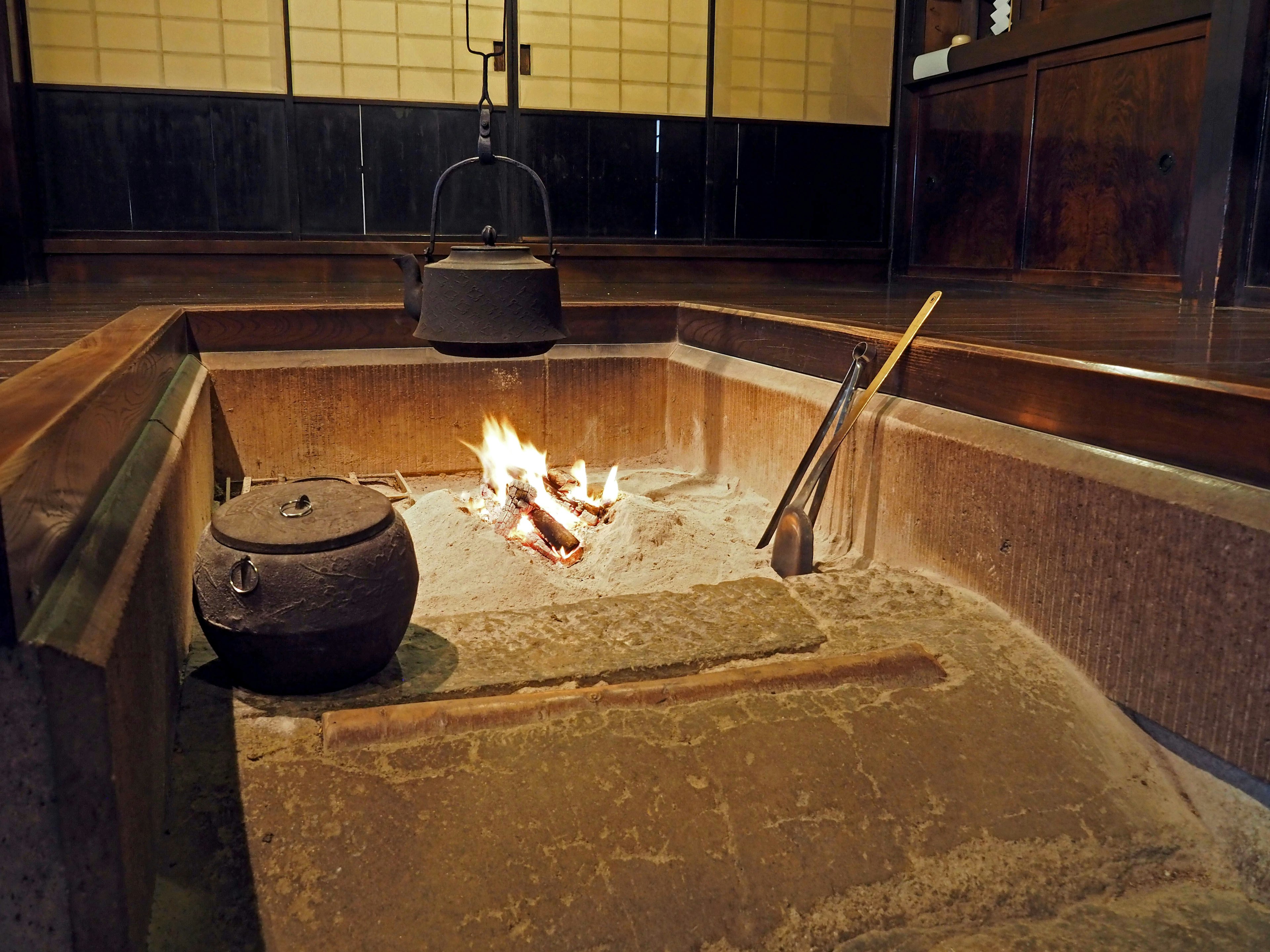 Irori japonés tradicional con fuego y tetera de hierro