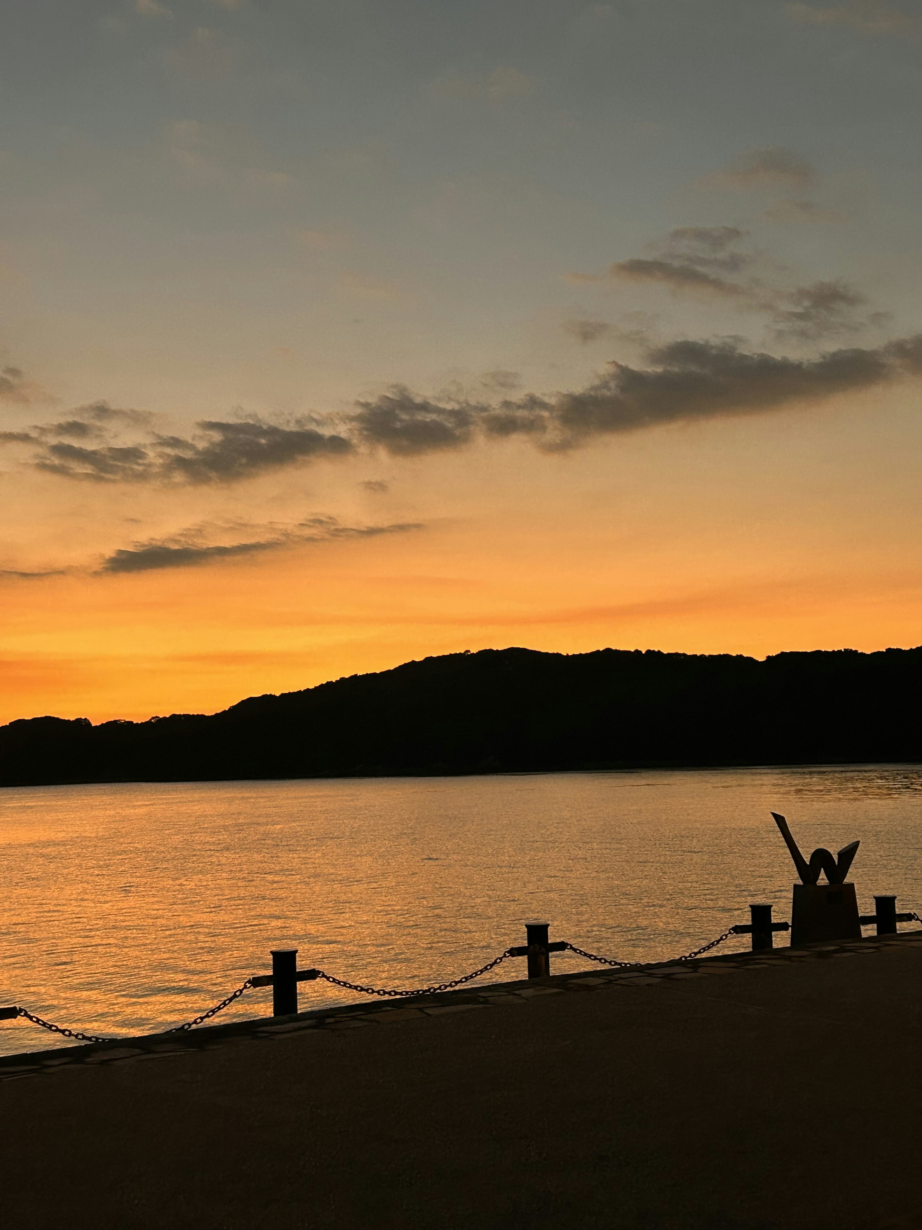 Hermoso atardecer sobre el mar con silueta de montaña