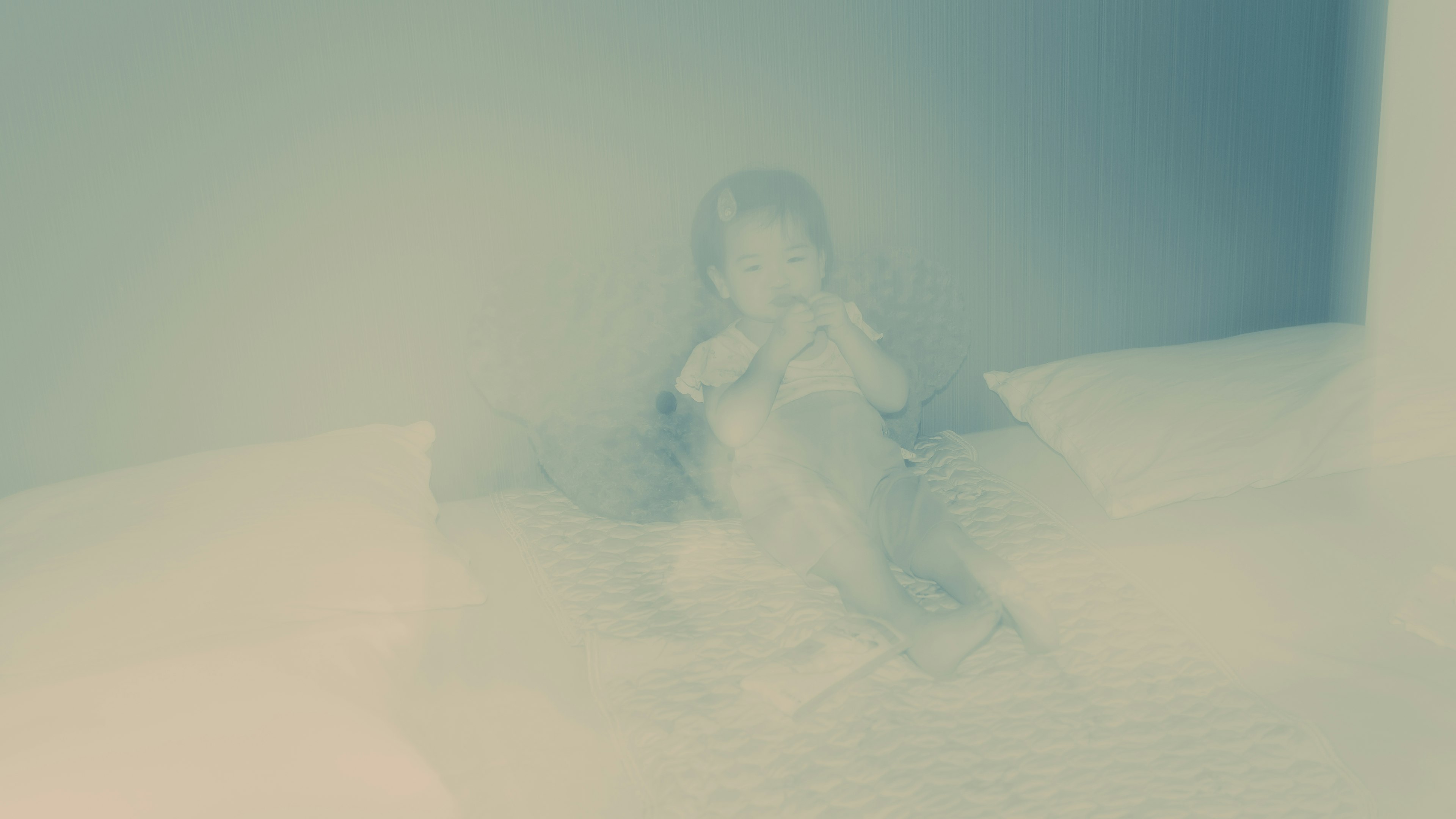 A blurry child sitting on a bed