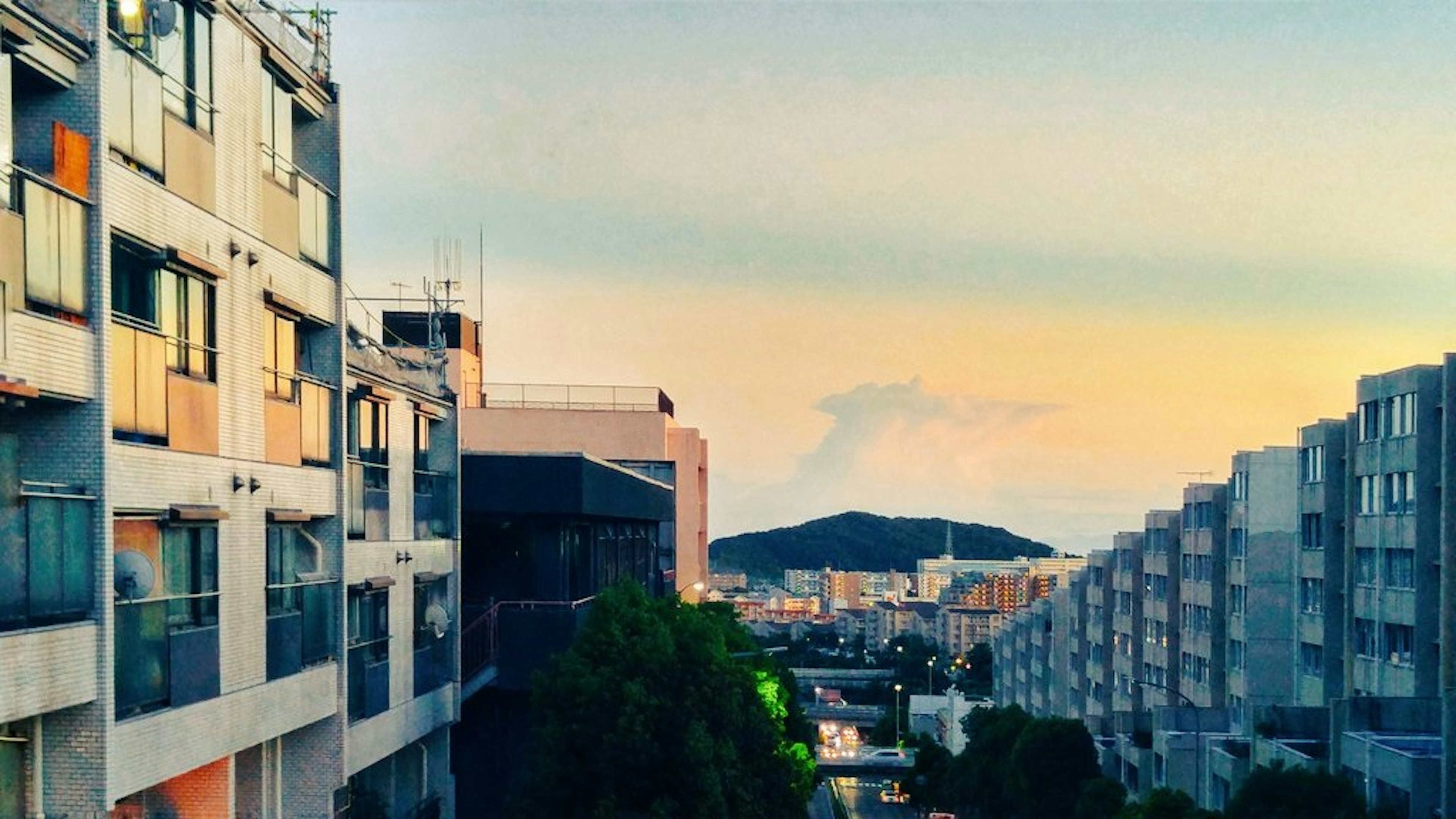 夕暮れ時の都市風景 建物と山が見える