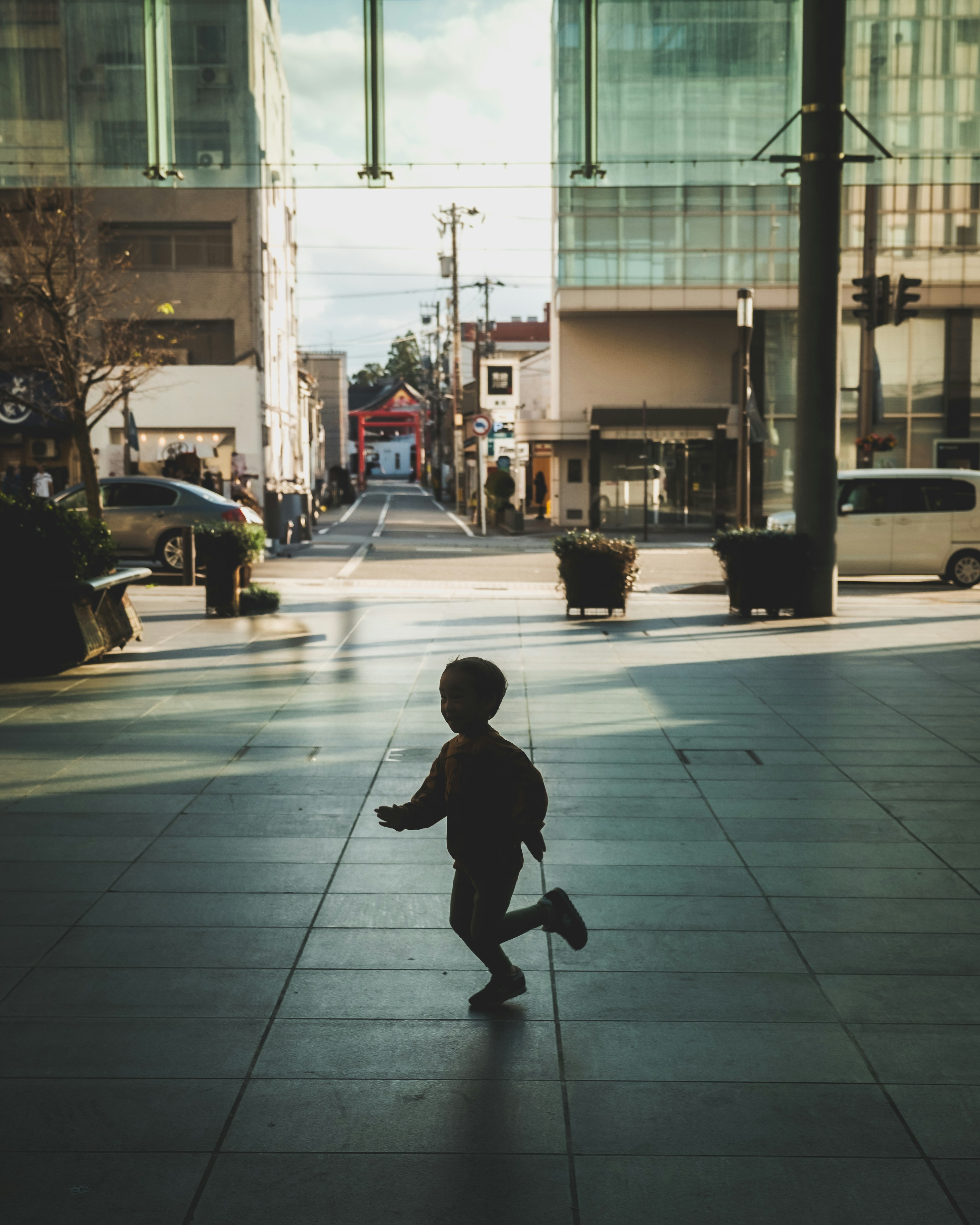 Bambino che corre in un paesaggio urbano con edifici e strade visibili