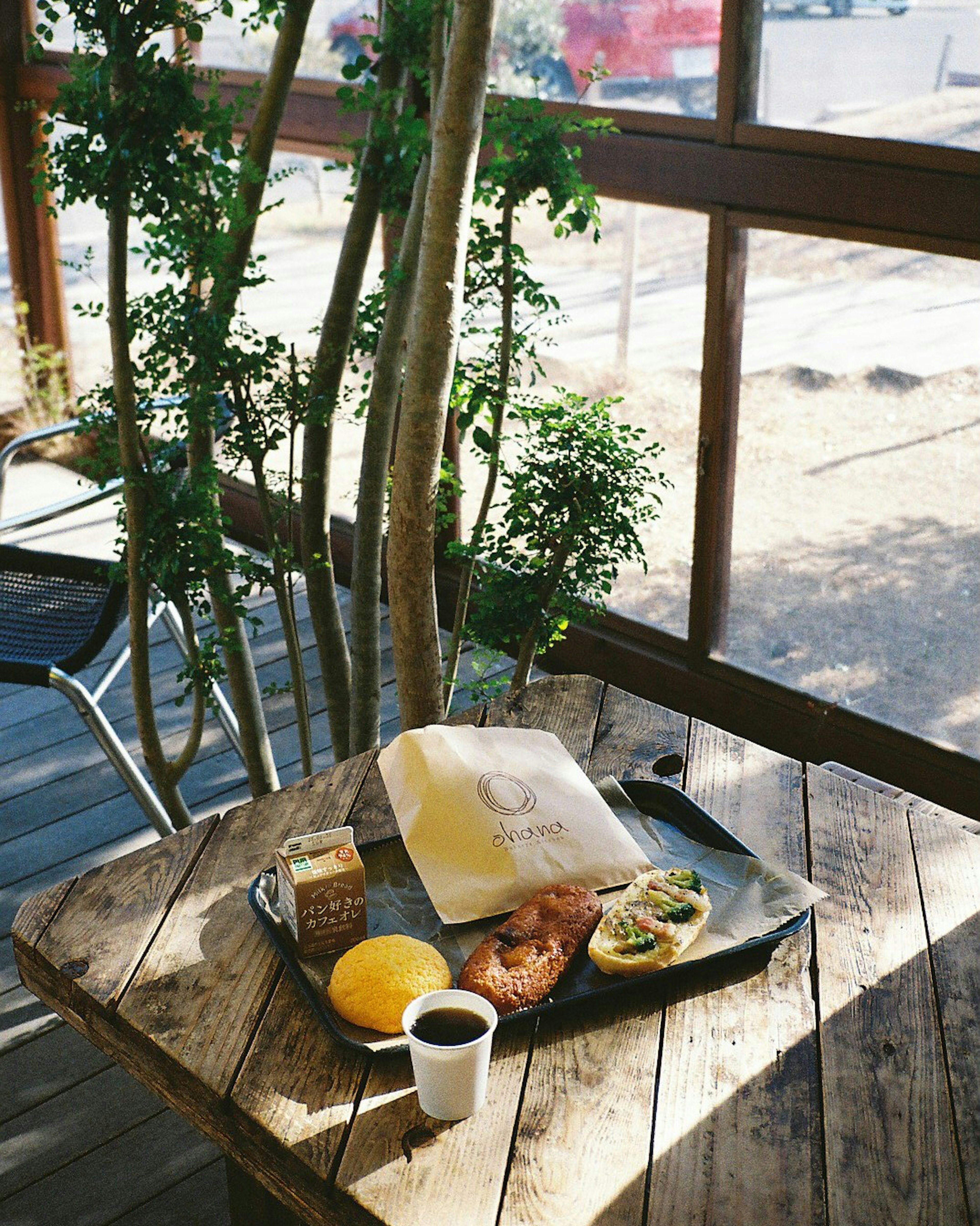 Ein Frühstückstablett auf einem Holztisch mit Brot und Obst Kaffee und Saft sind enthalten