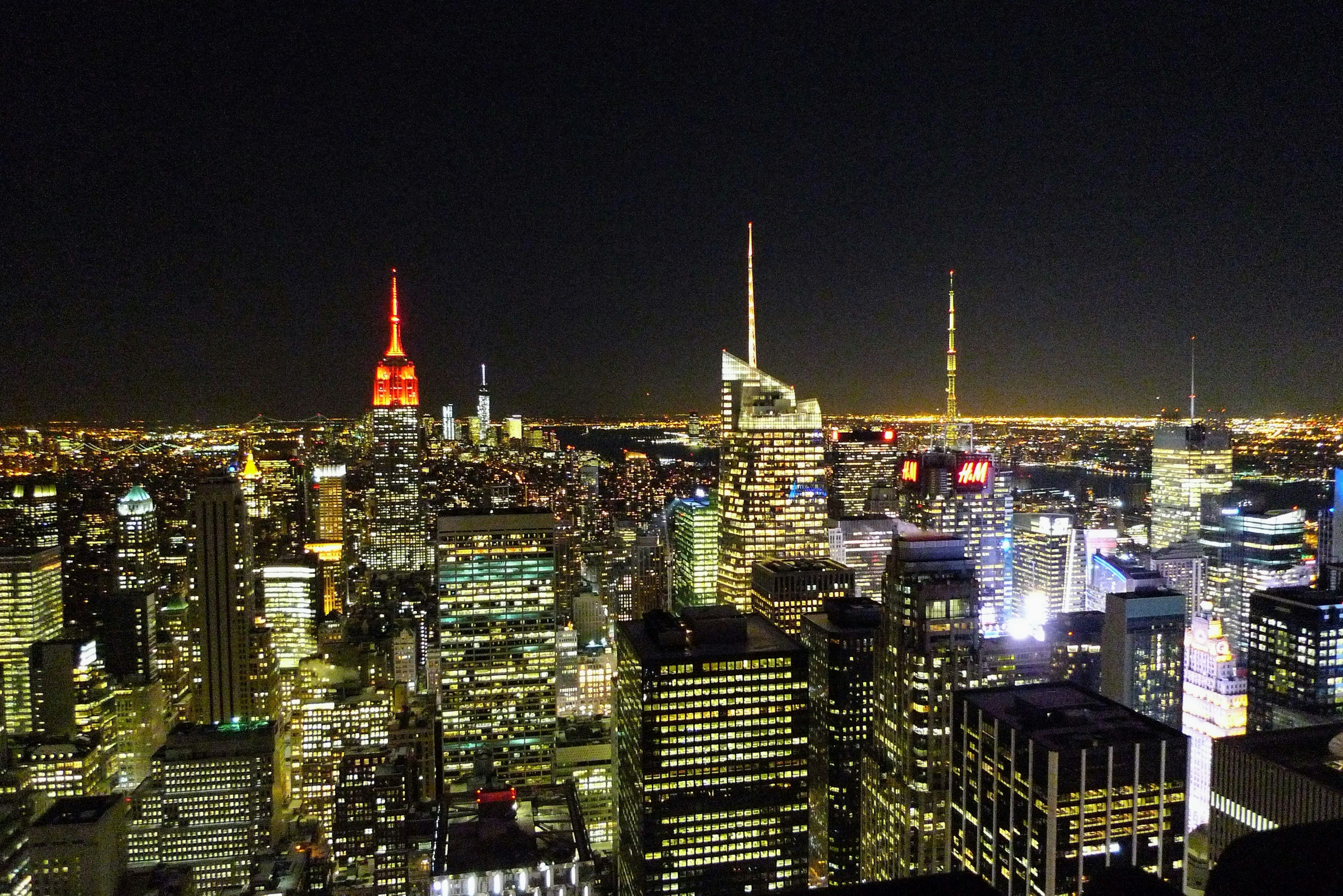 Night view of New York skyline featuring Empire State Building with red light