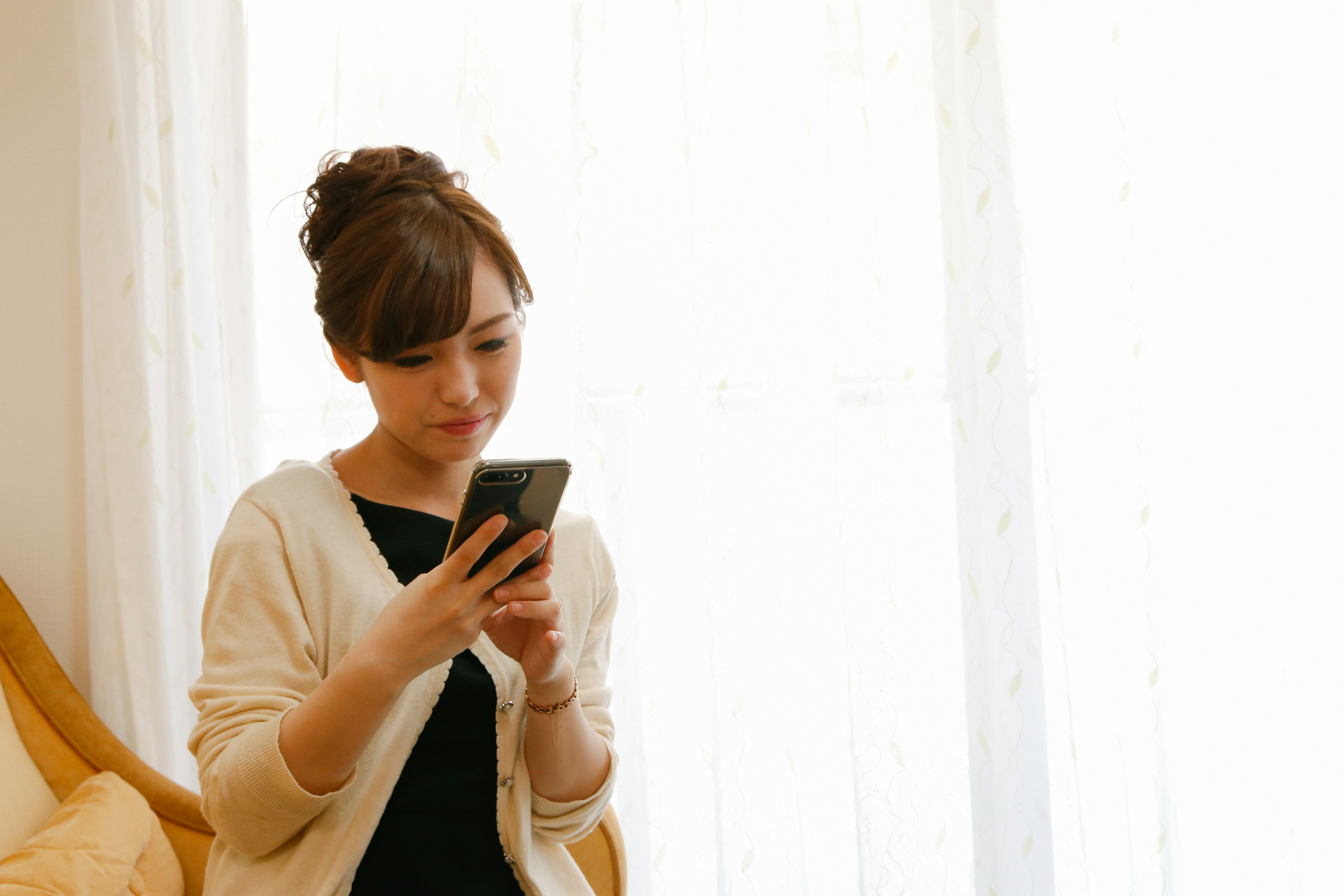 Donna che guarda lo smartphone in un ambiente interno luminoso