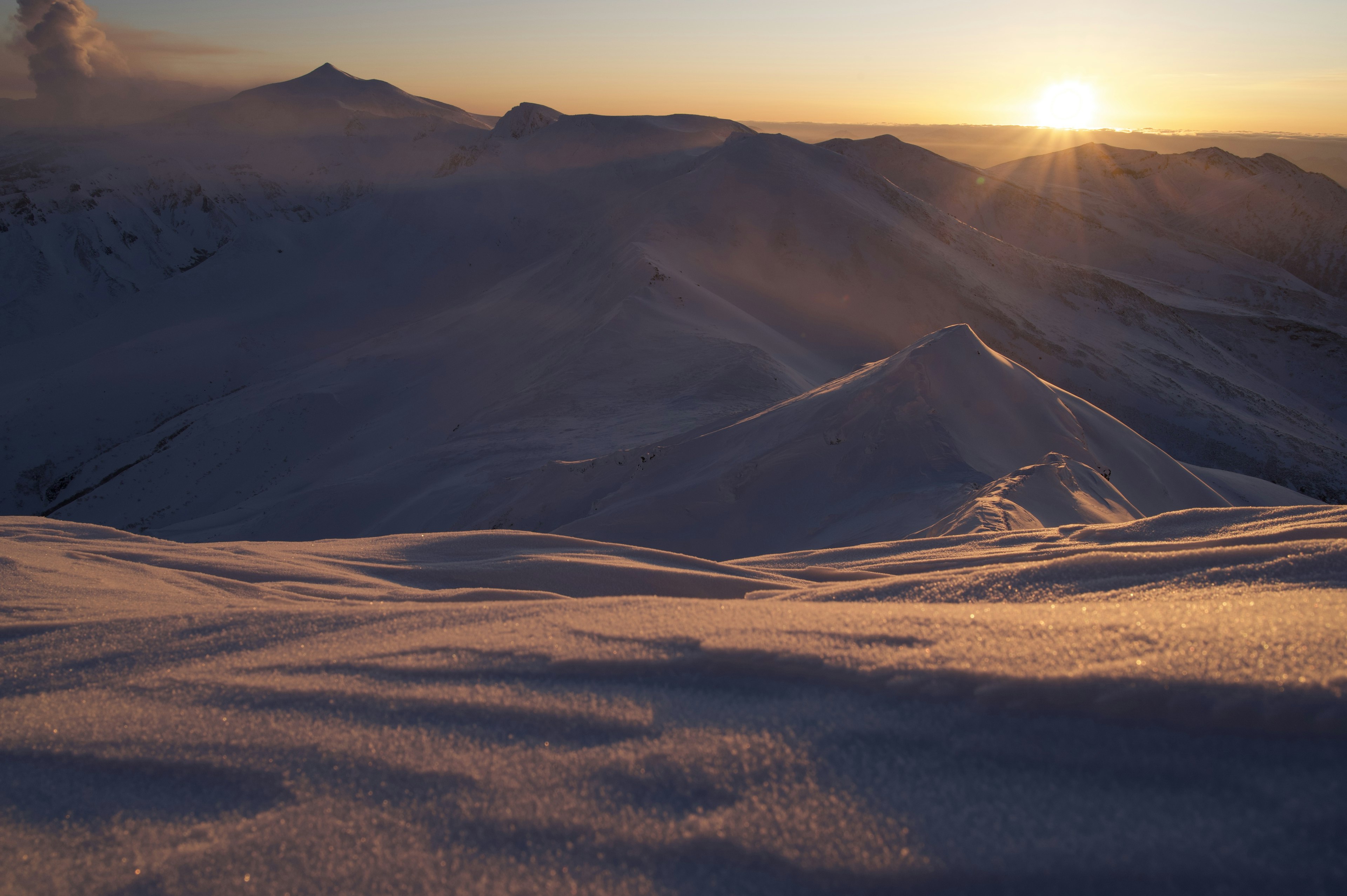 Montañas cubiertas de nieve con un atardecer radiante