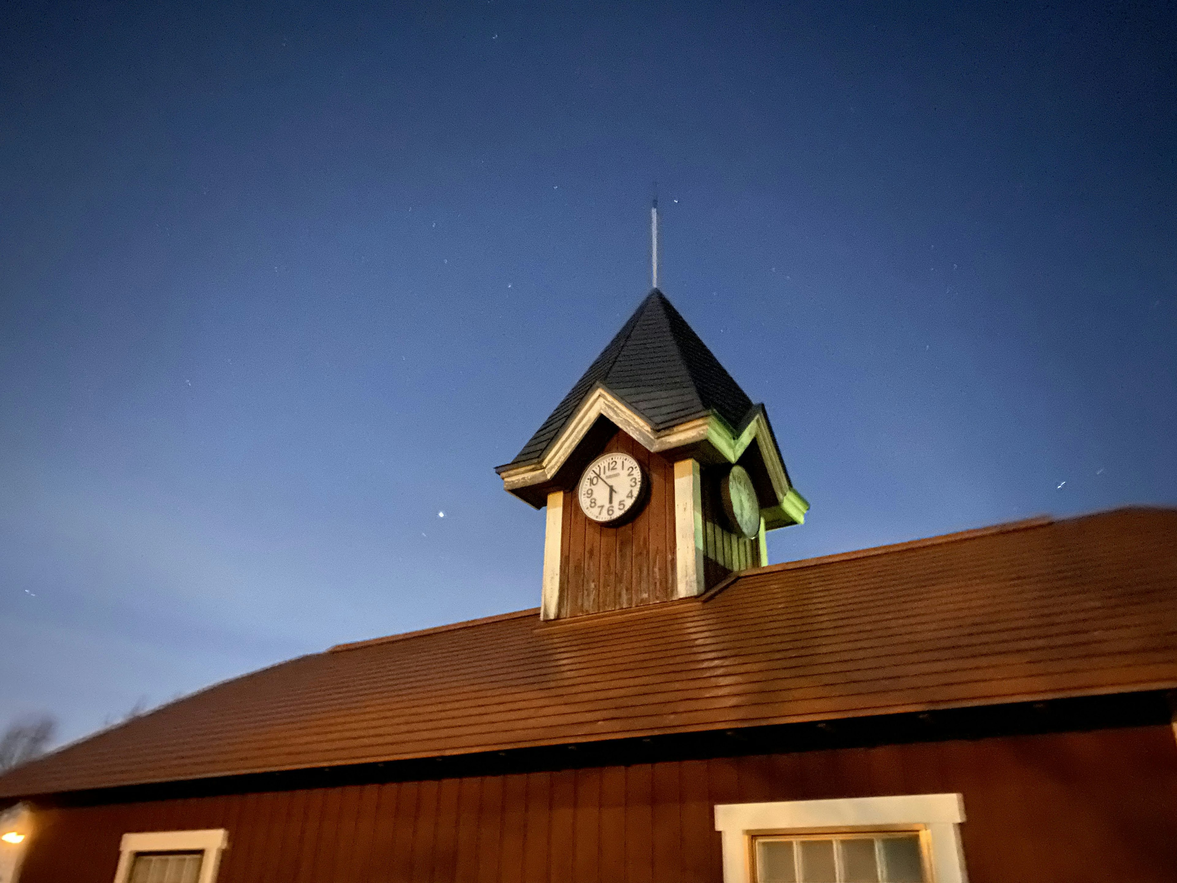 Clock tower with a pointed roof under a blue sky