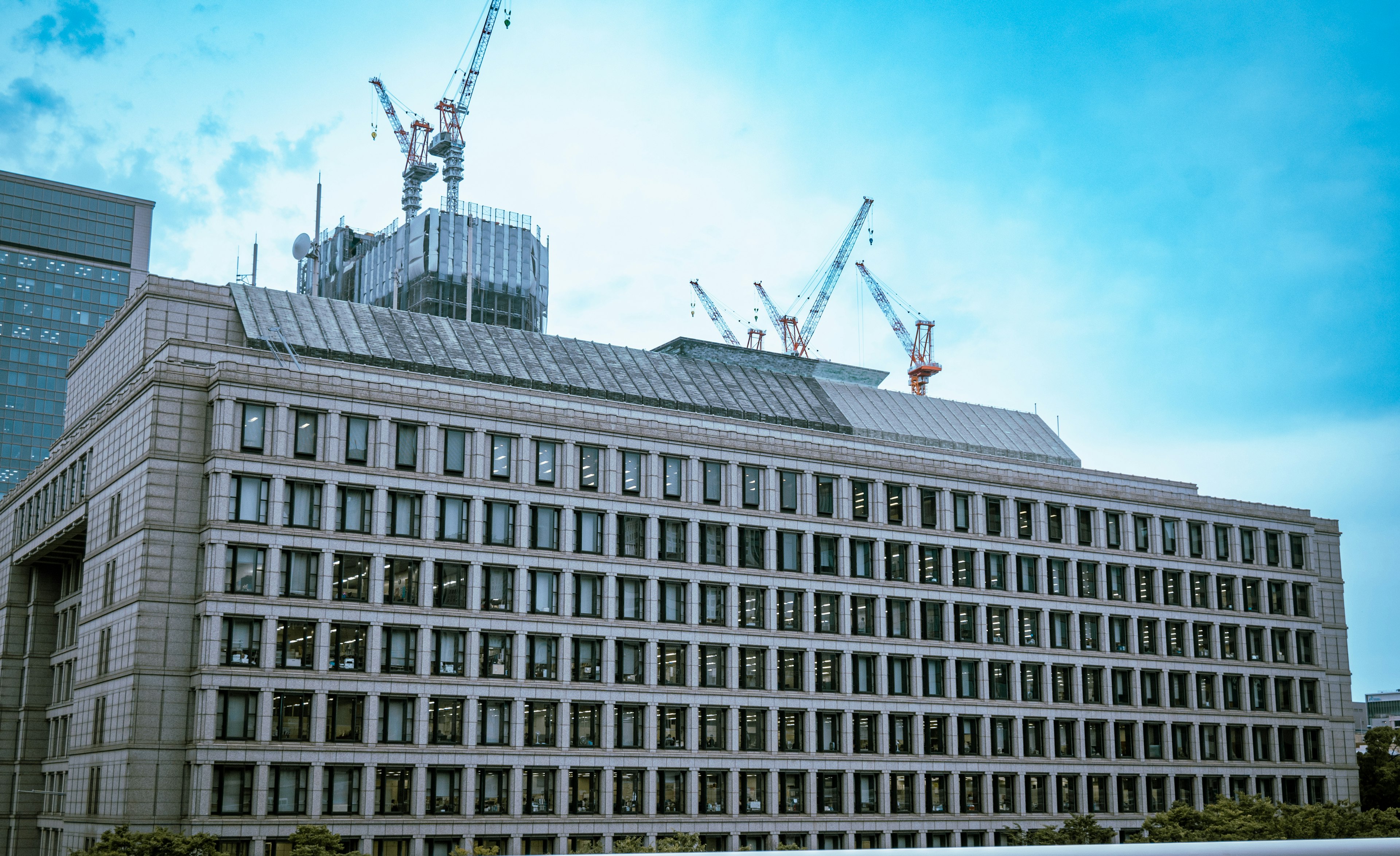 Site de construction avec des grues visibles sur un bâtiment moderne