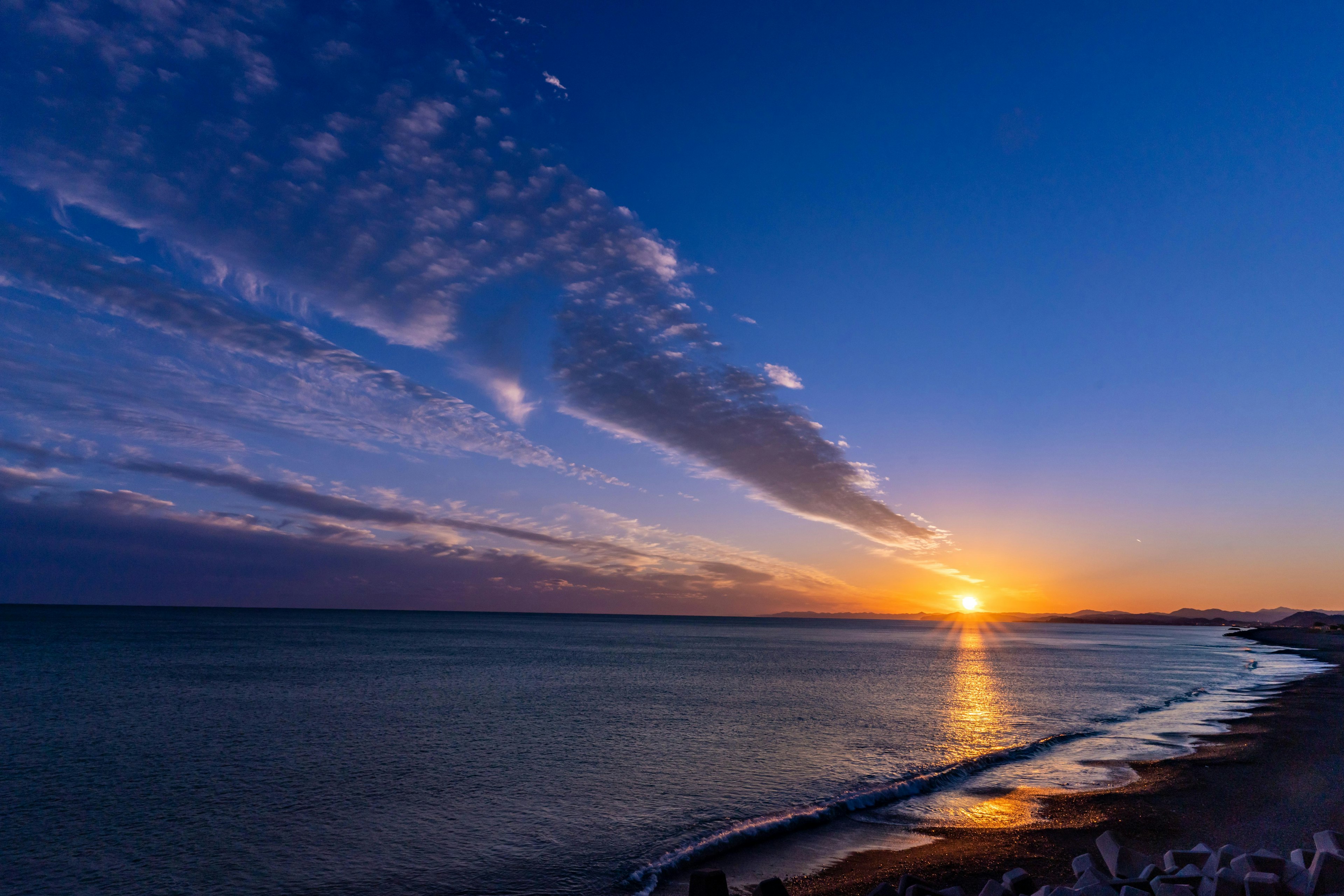 海岸線に沈む夕日と美しい青空