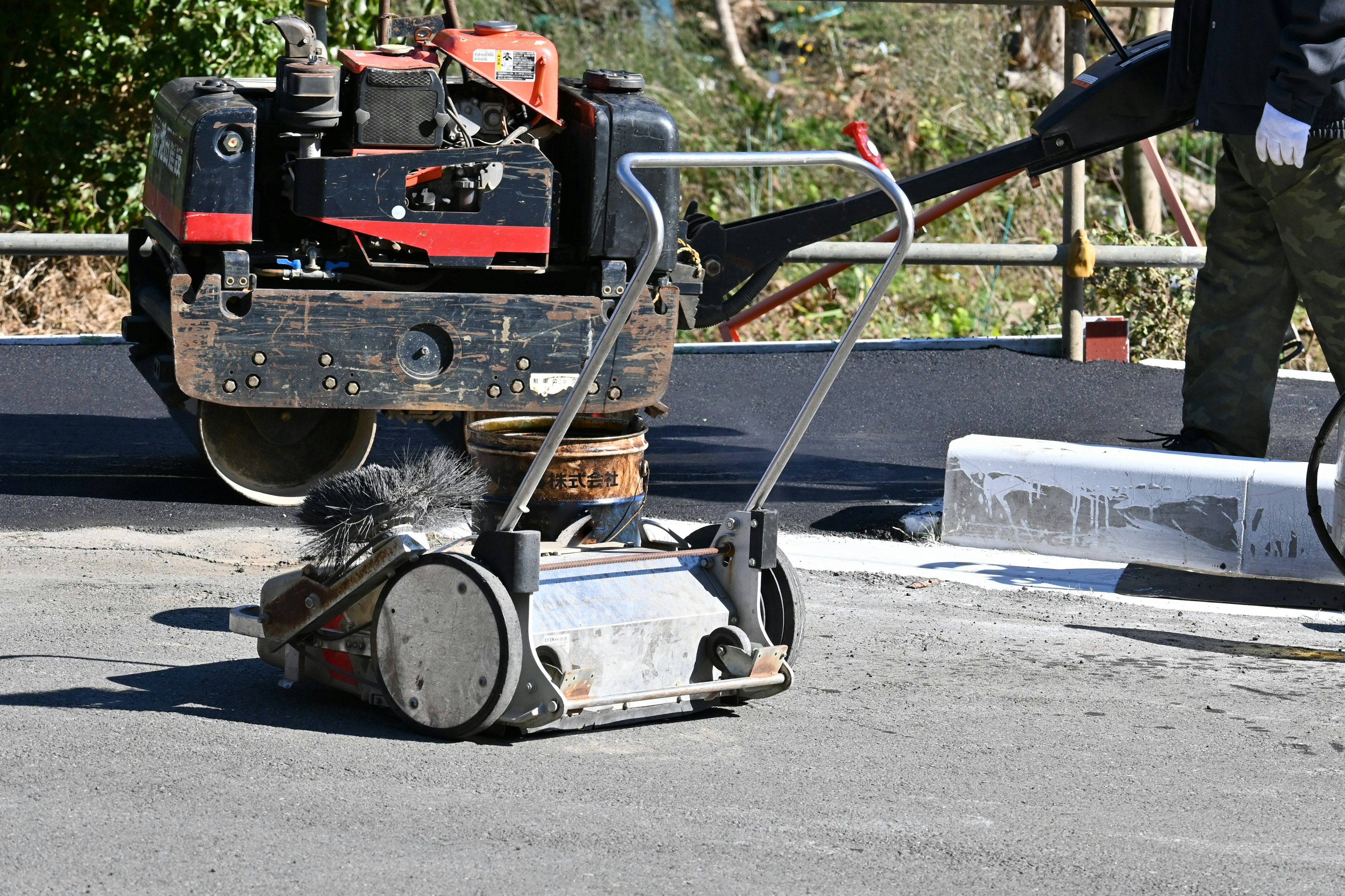 Bau-Szene mit einer Walze und Maschinen auf dem Asphalt