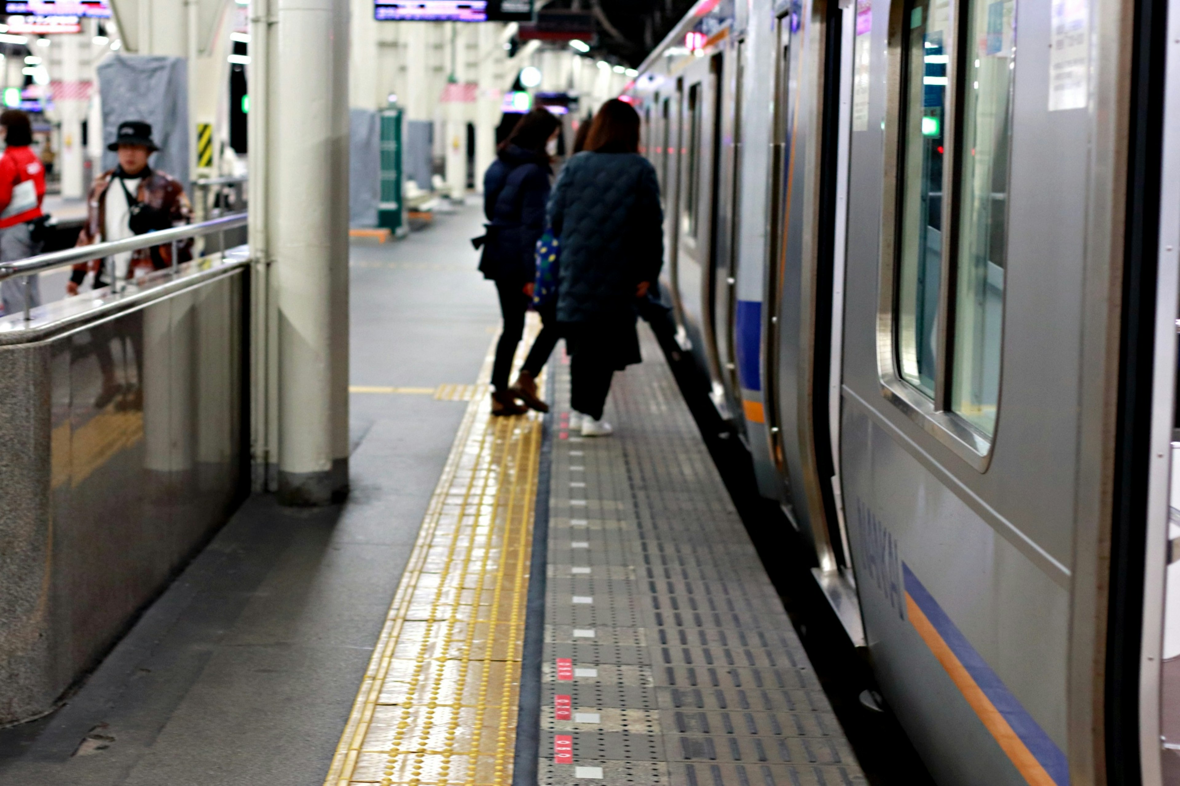 駅のプラットフォームに立っている乗客と電車