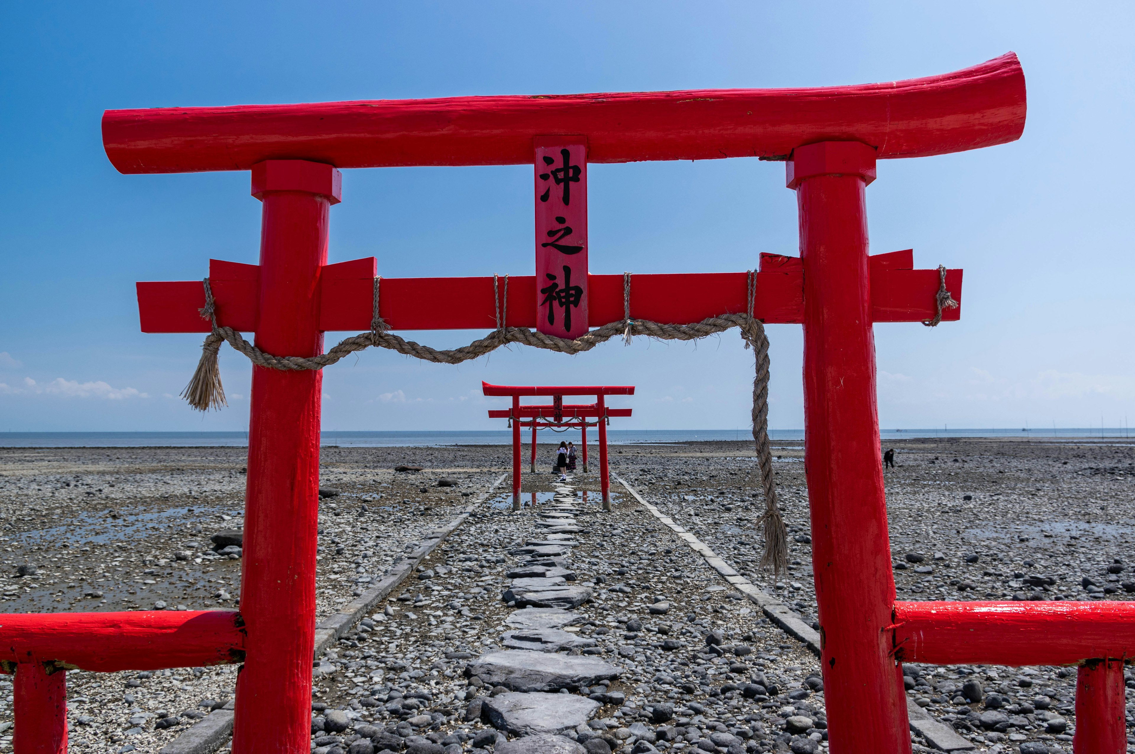 A coastal view featuring a series of red torii gates