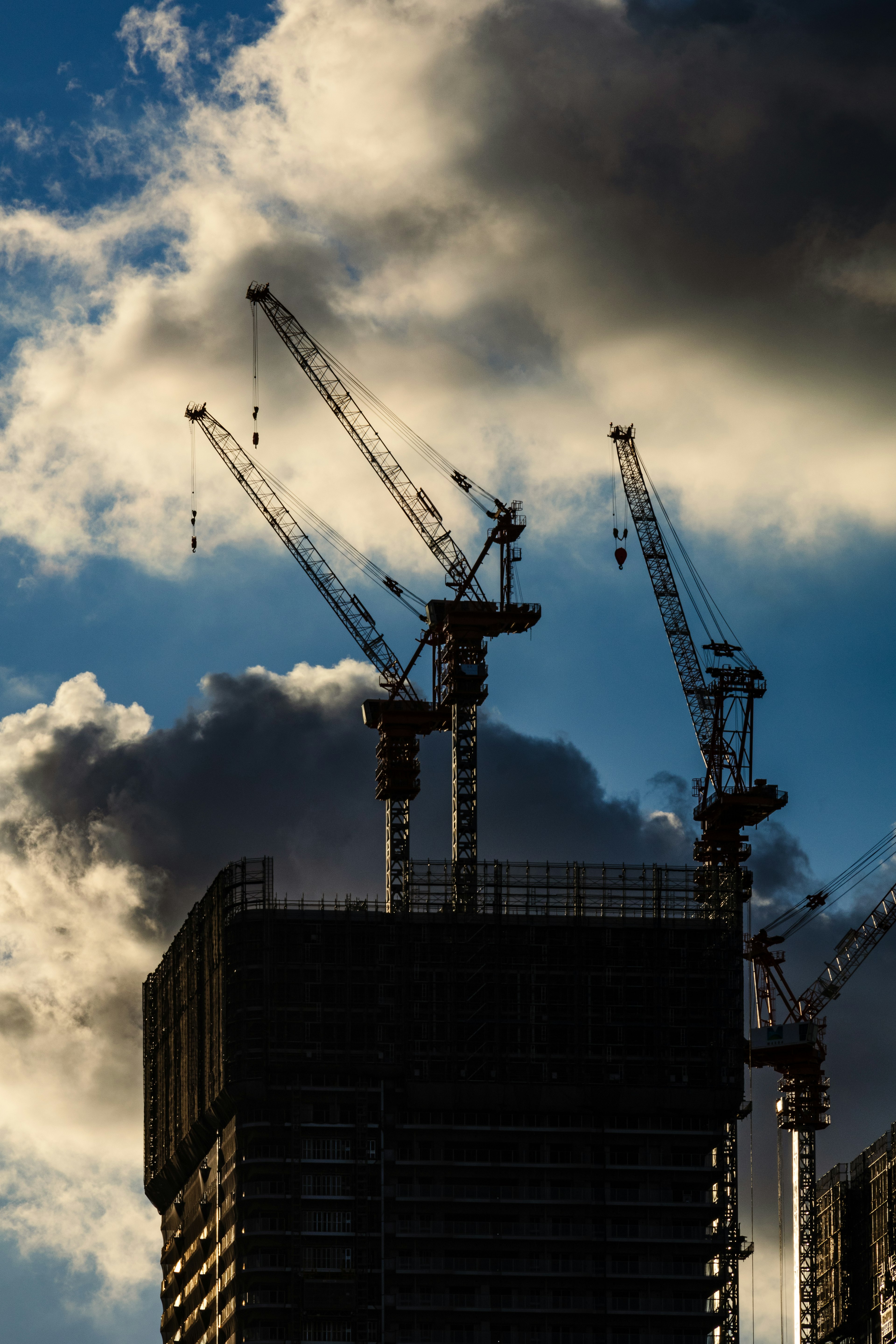 Siluet gedung bertingkat dalam pembangunan dengan crane