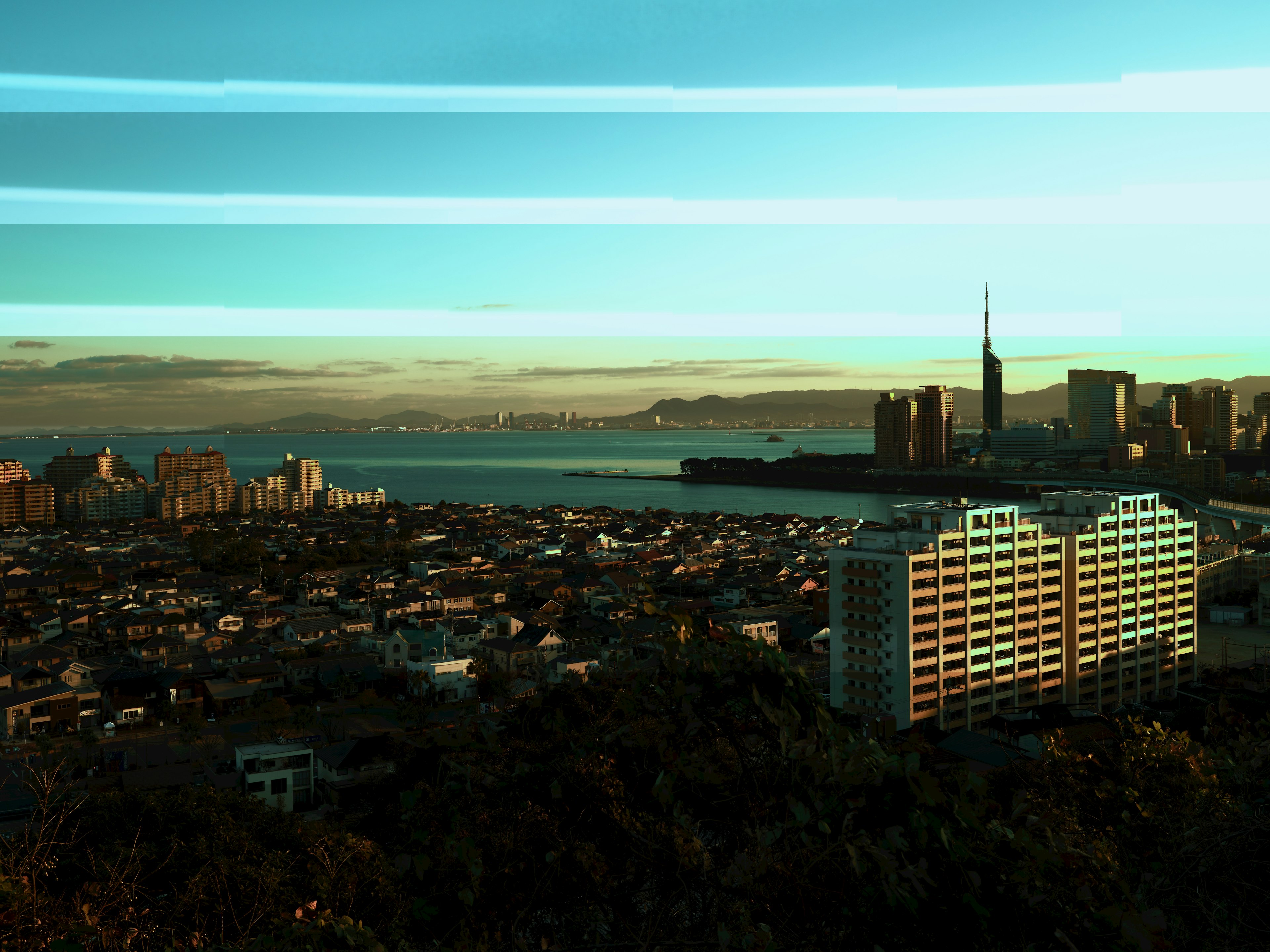 Paisaje urbano con cielo azul y mar que presenta altos edificios y áreas residenciales