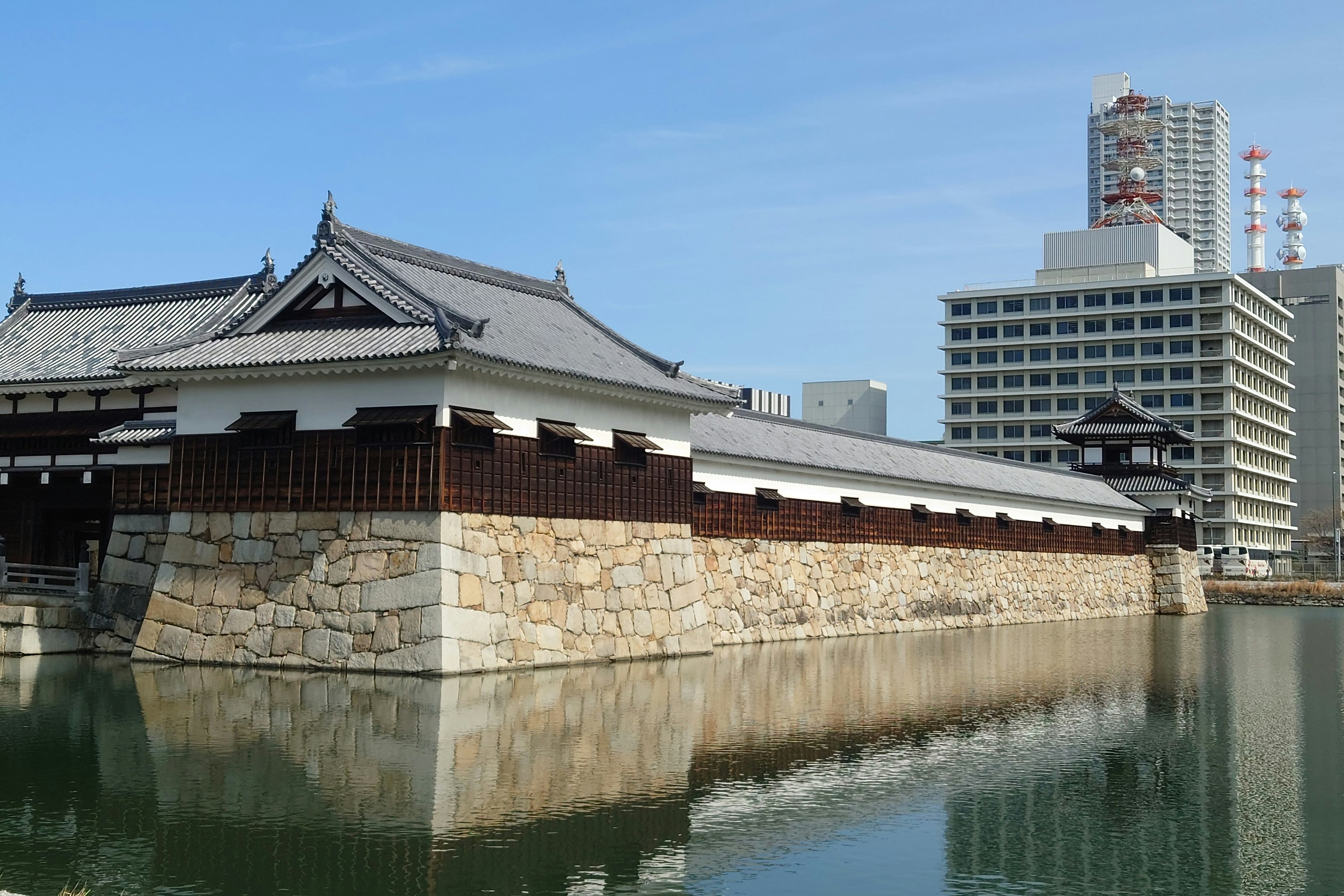 Historic castle wall juxtaposed with modern buildings