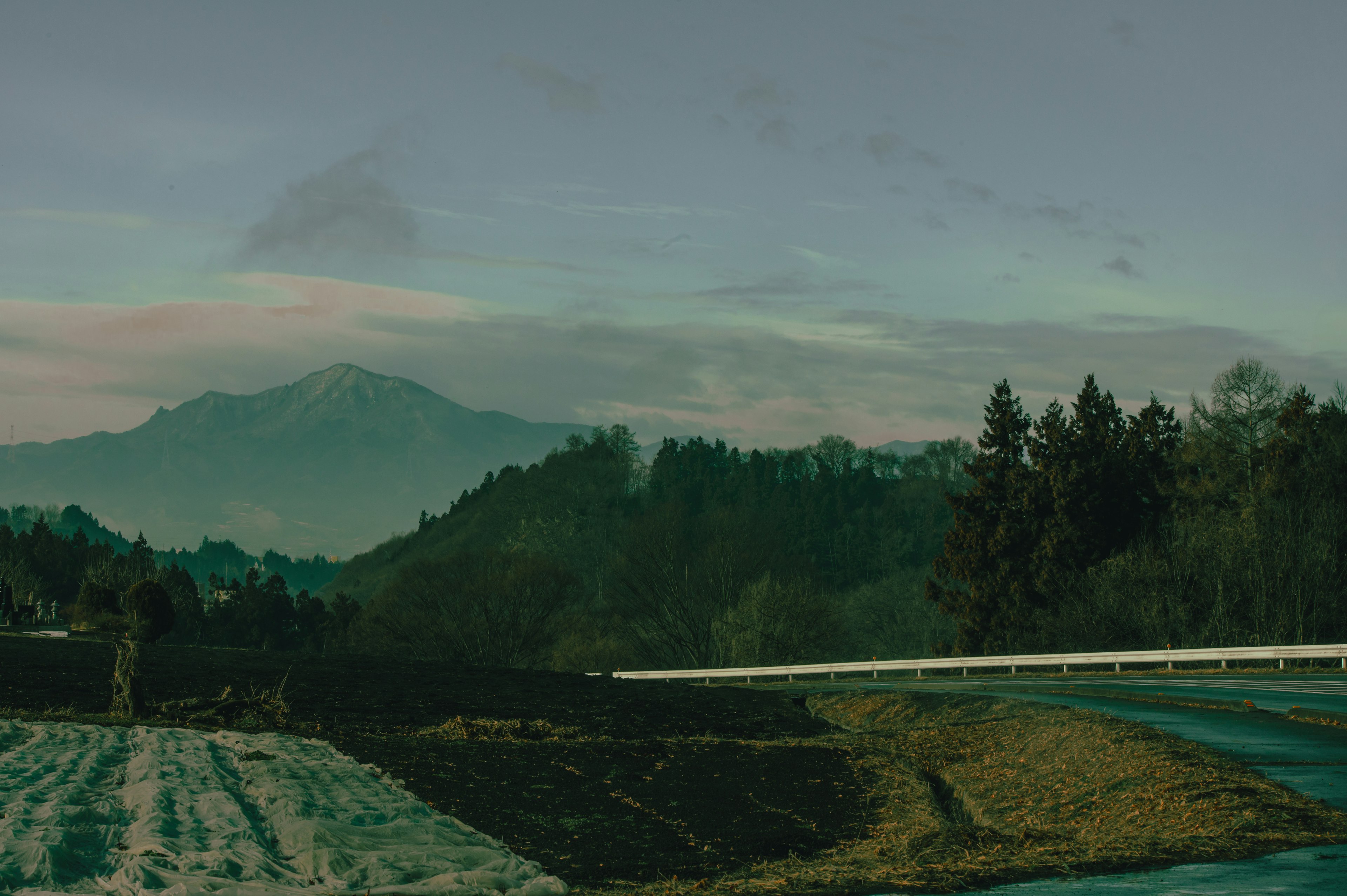 Rural landscape with mountains in the background and a quiet road