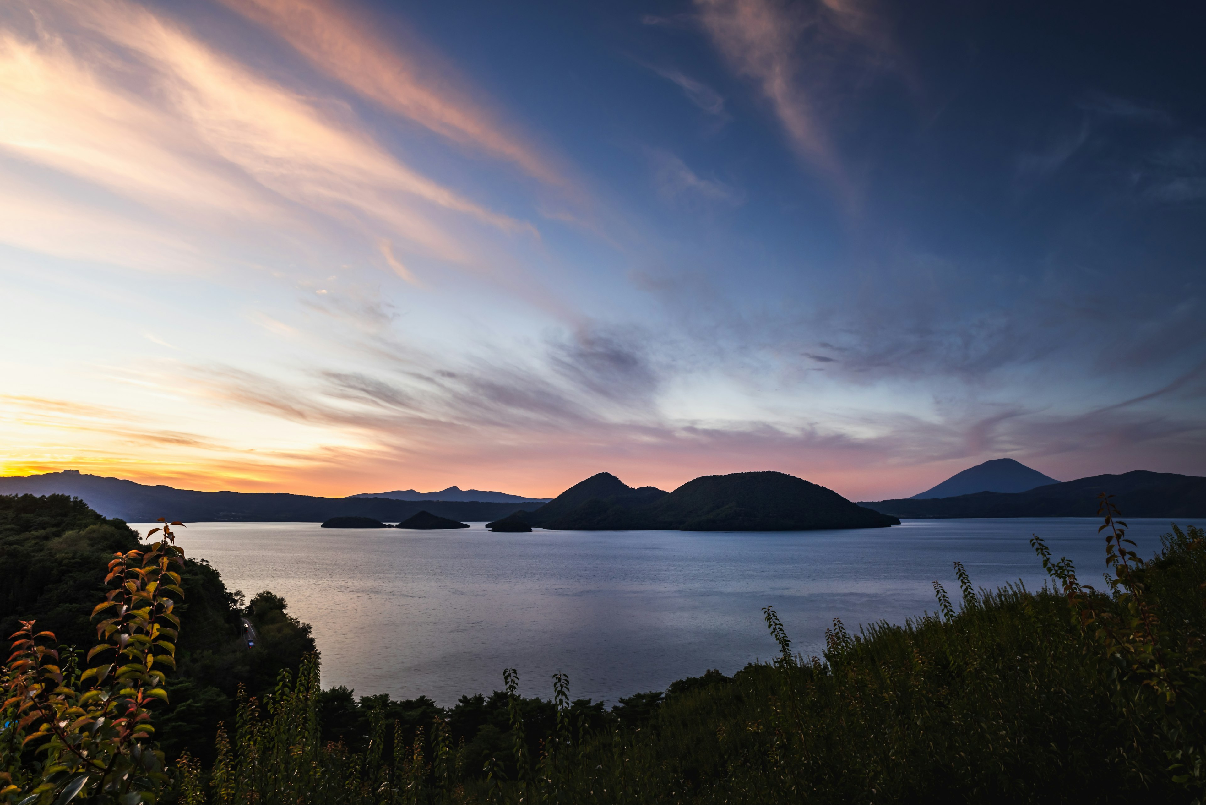 Vue pittoresque d'un lac avec des montagnes au coucher du soleil