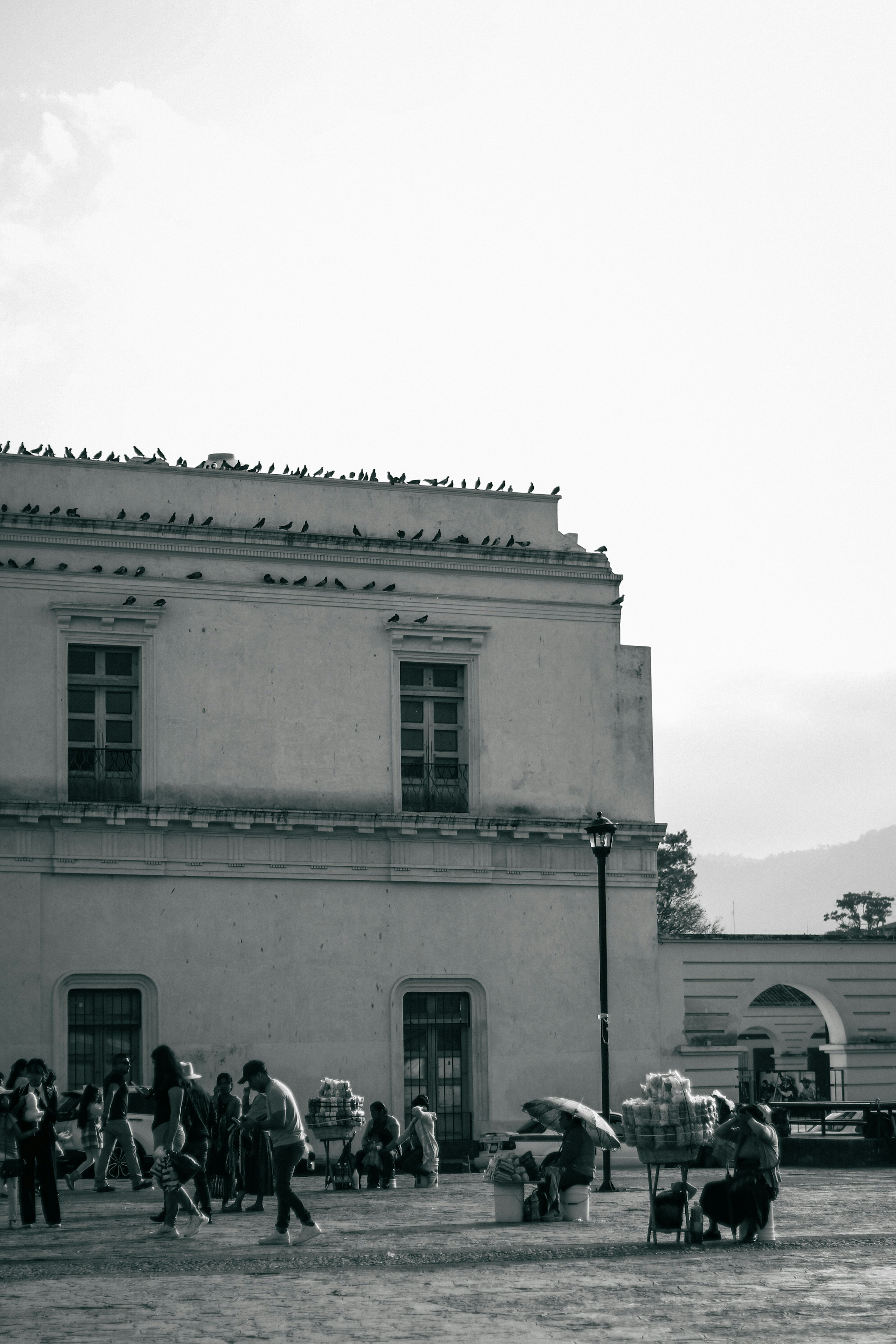 Bâtiment historique en noir et blanc avec des personnes dans une place animée