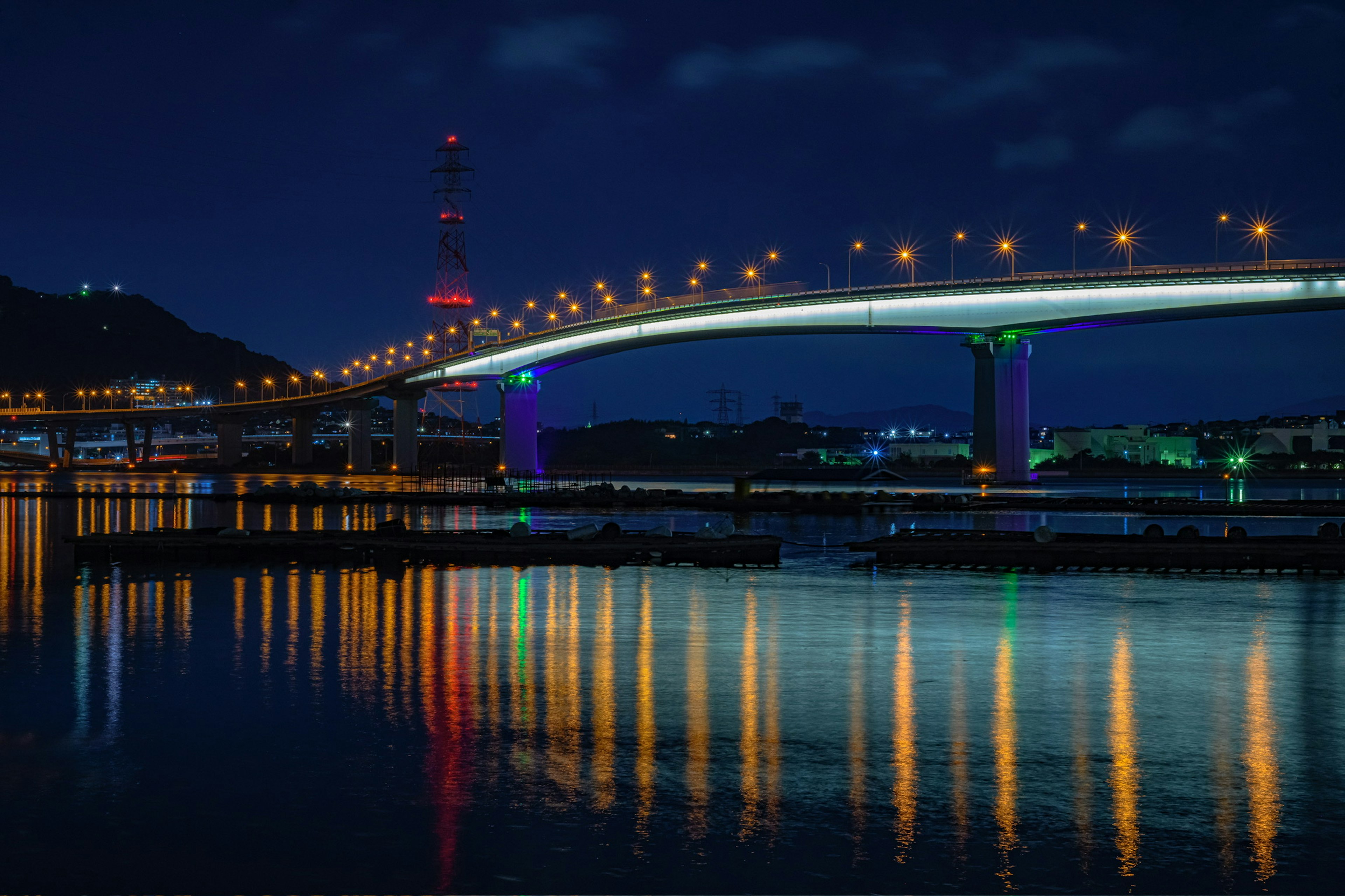 Pemandangan malam yang indah dari jembatan yang memantul di air