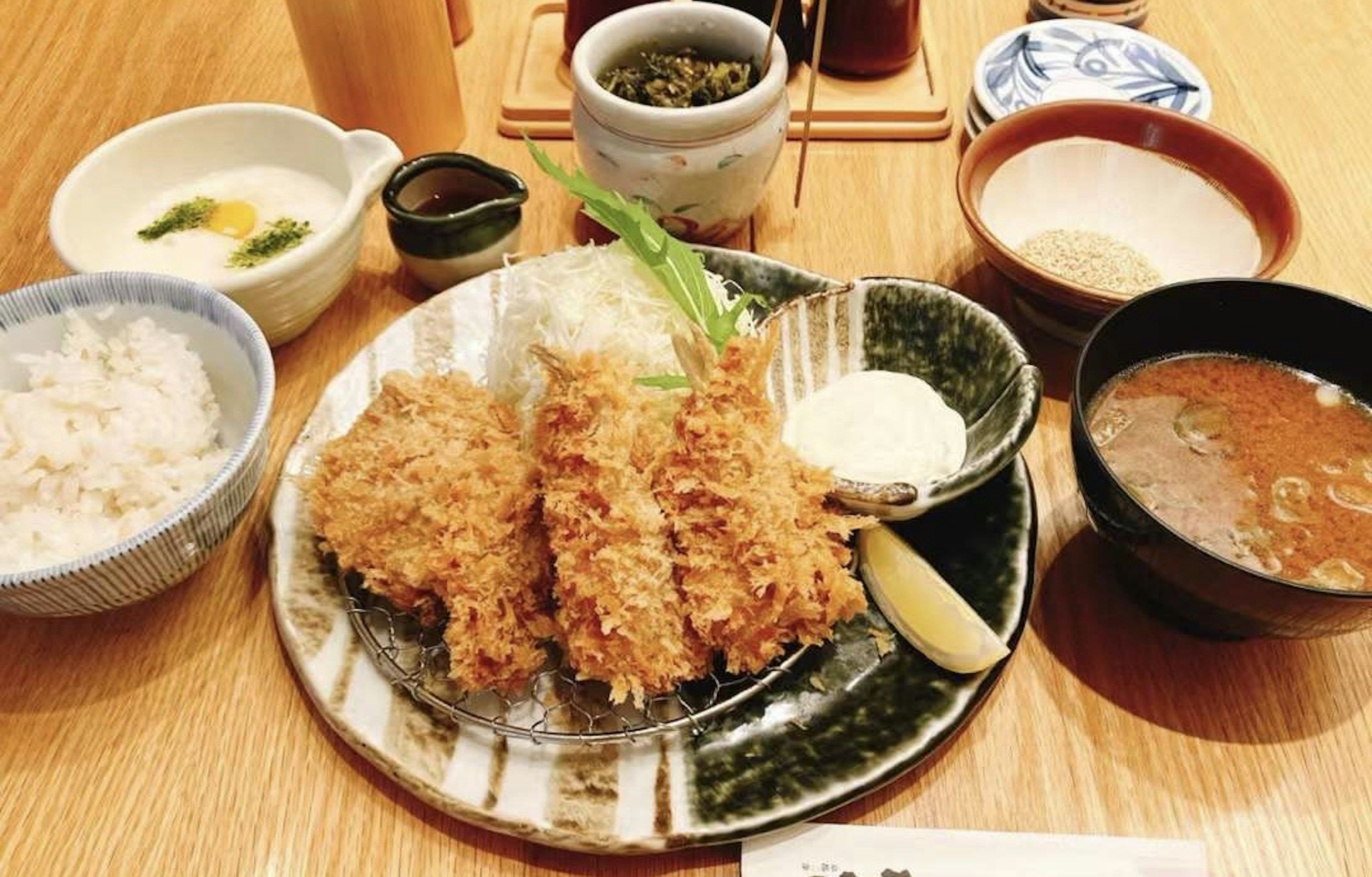 A Japanese meal featuring a plate of katsu with rice and miso soup