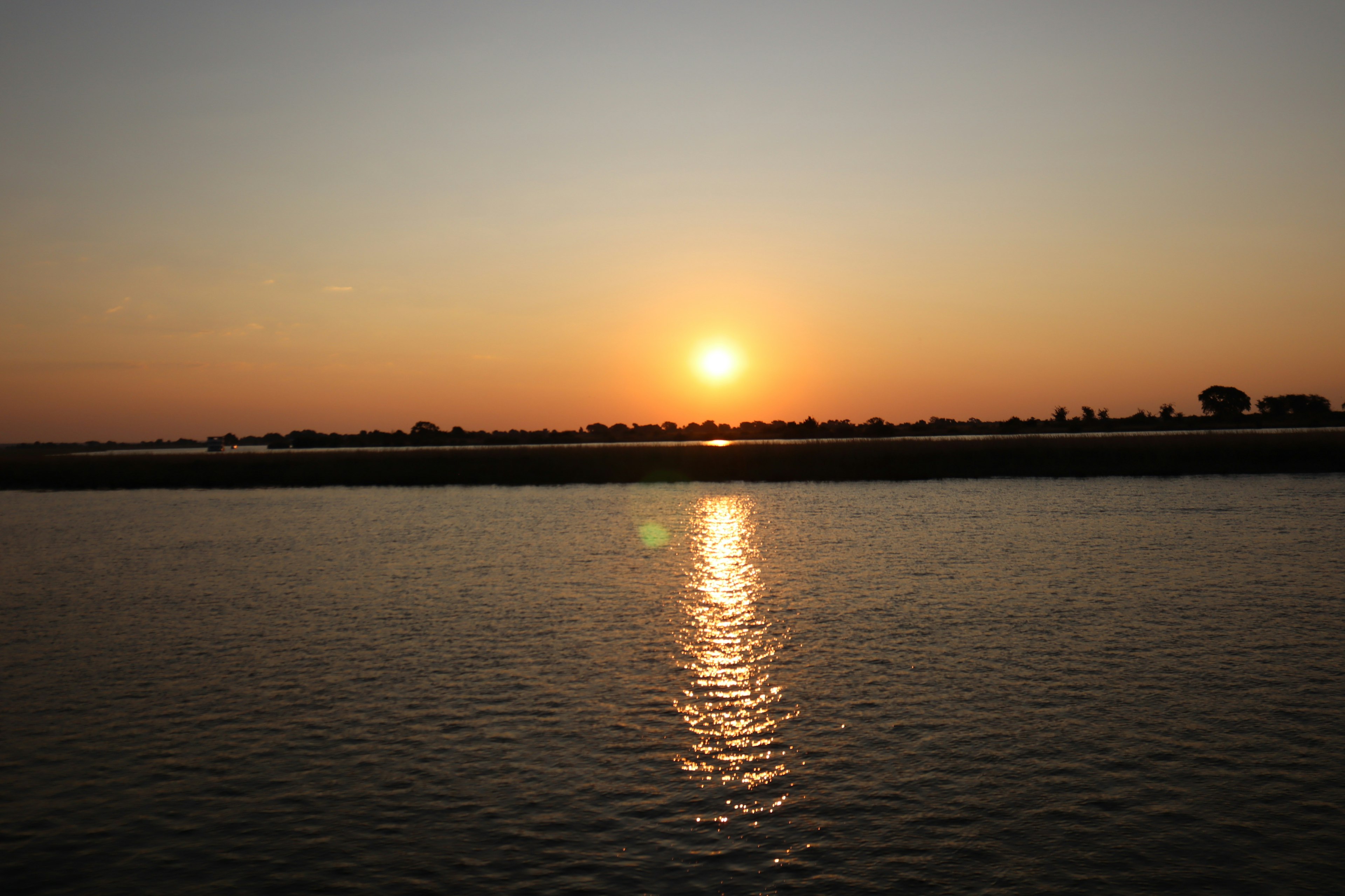 Schöne Landschaft mit Sonnenuntergang, der sich im Wasser spiegelt