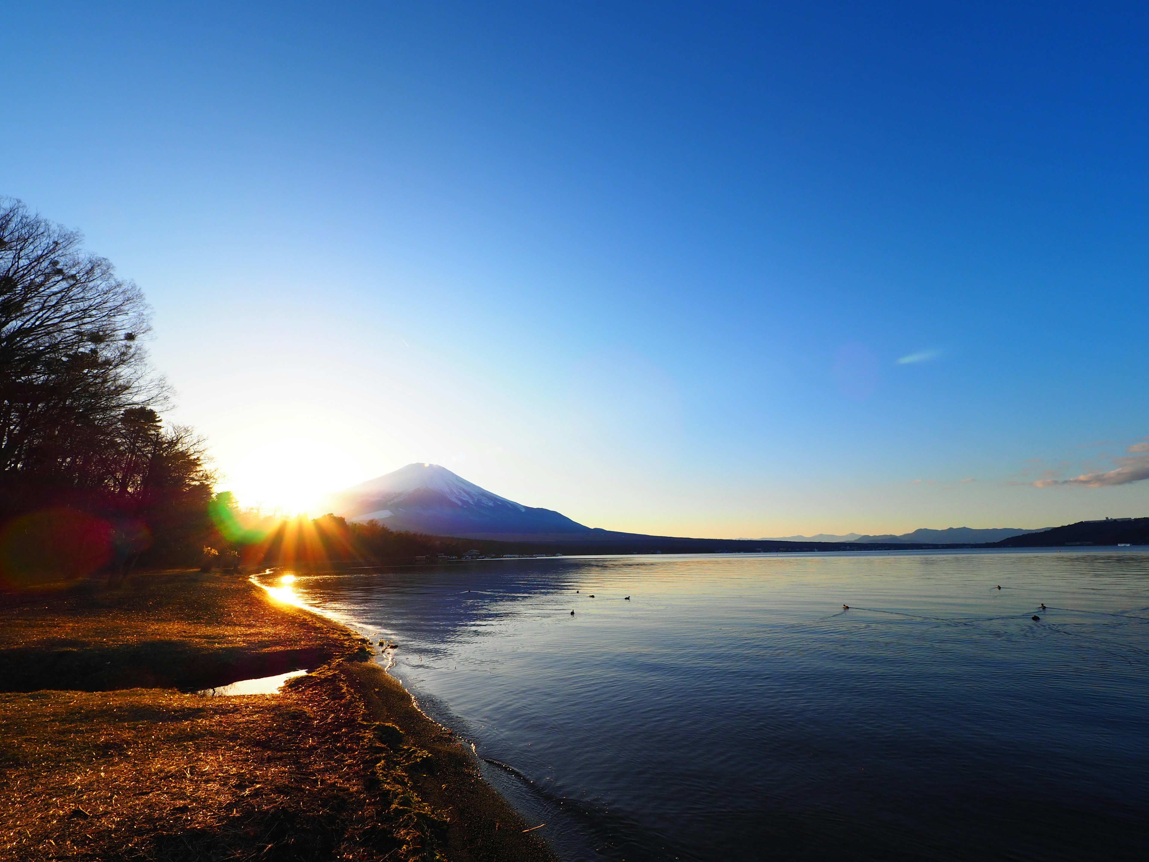 Pemandangan indah danau dan gunung dengan sinar matahari