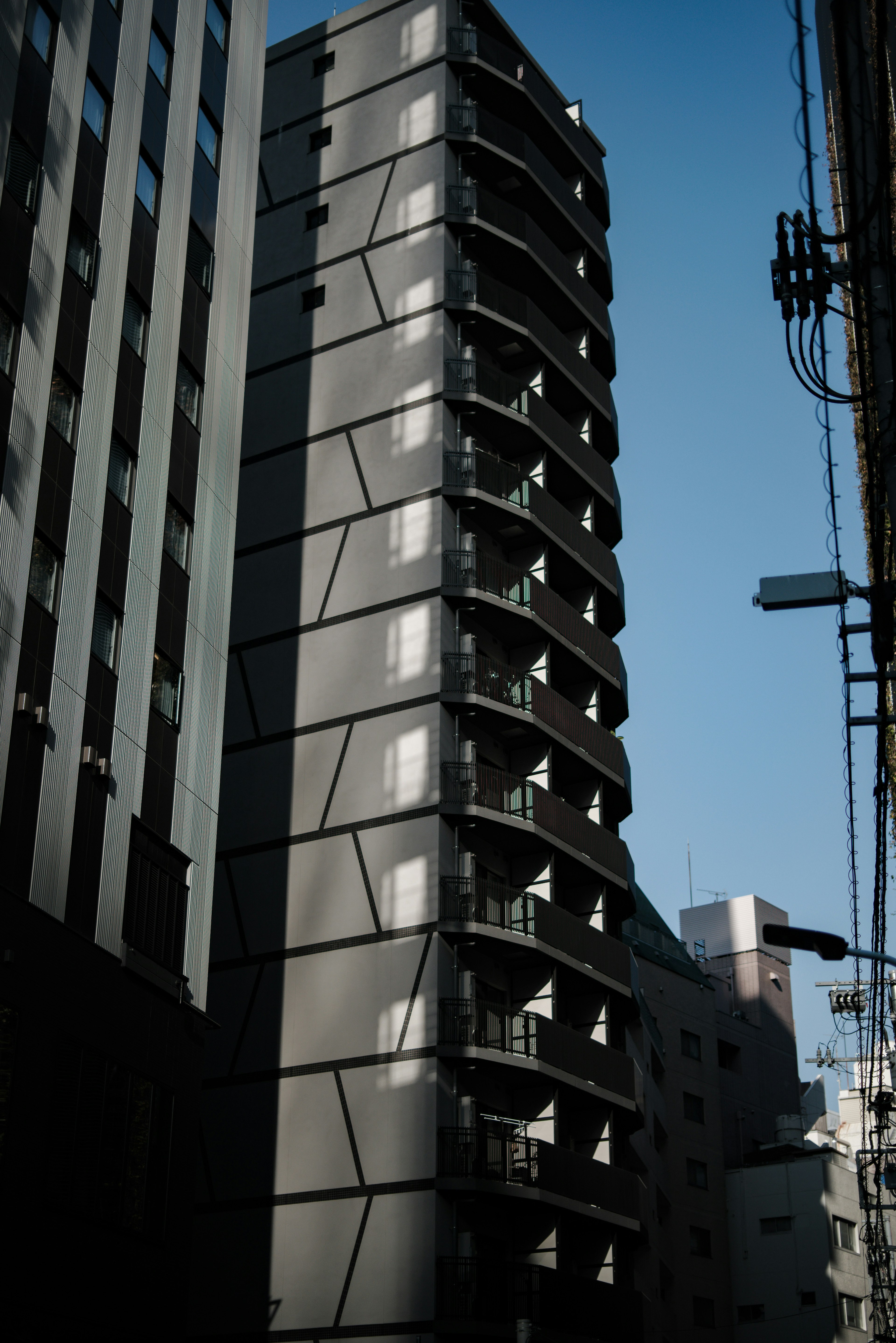 A modern high-rise building with a unique design under a clear blue sky