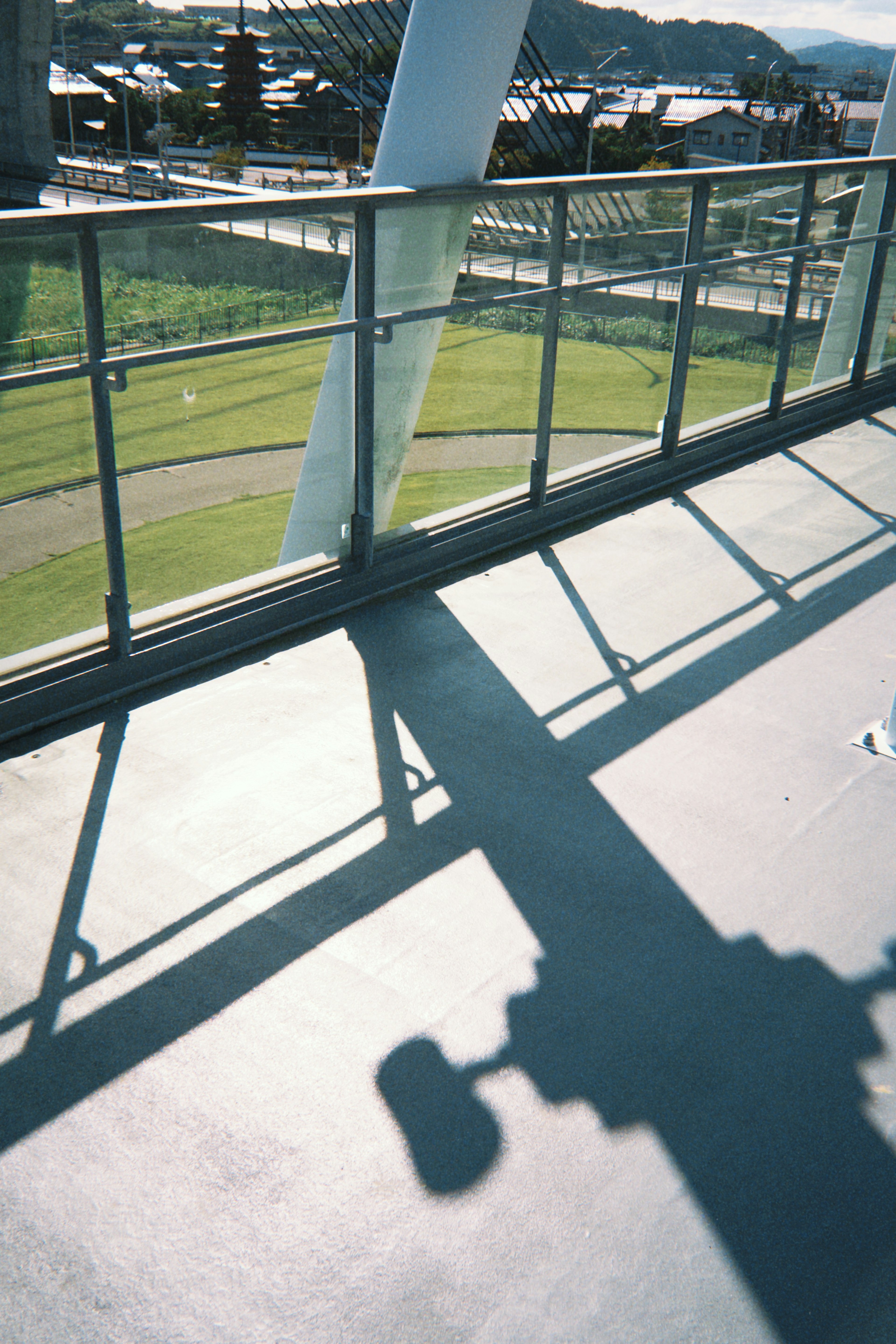 Balcony view with glass railing and shadows