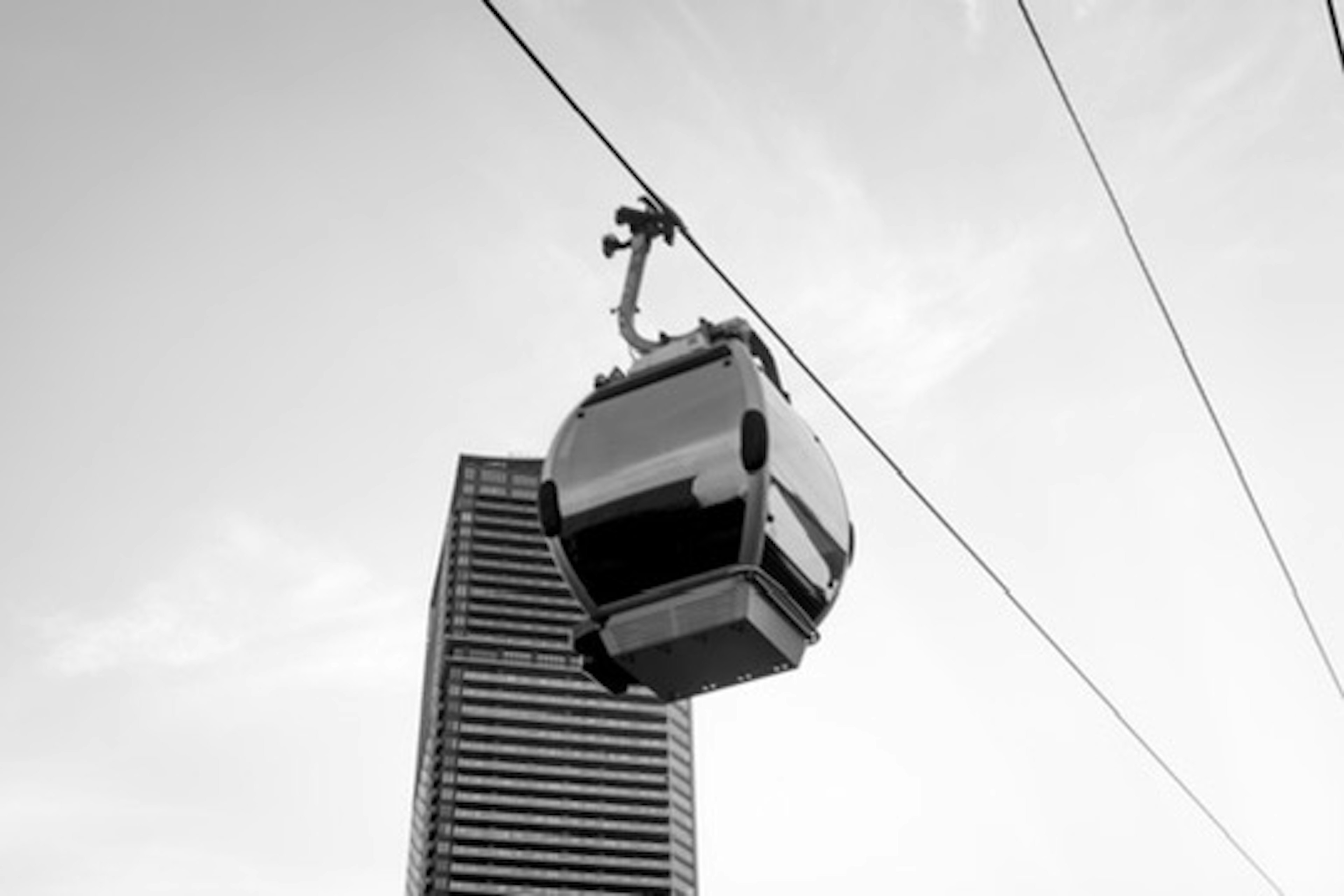 A cable car passing above a high-rise building