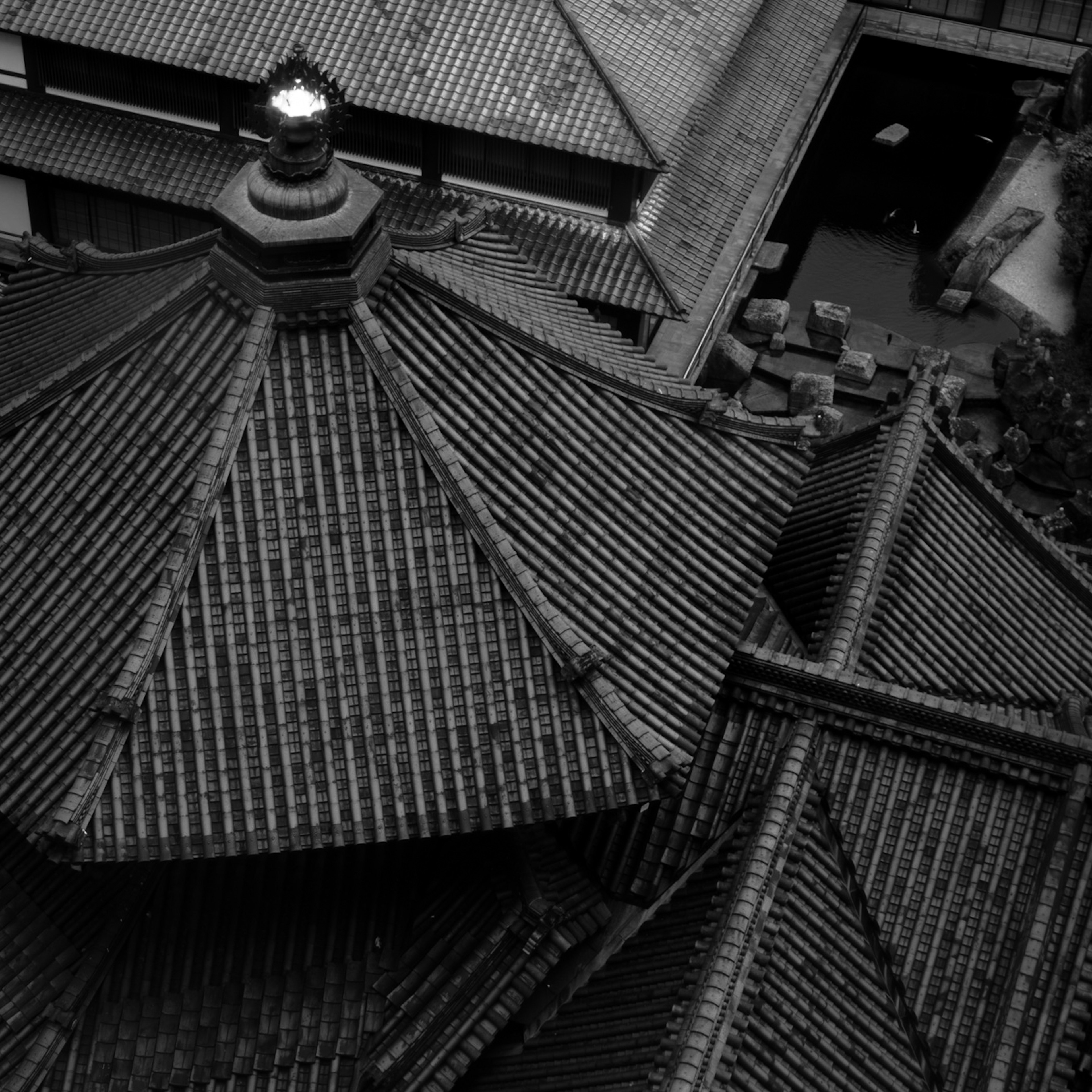 Black and white photo of traditional architecture viewed from above showing detailed tiled roofs