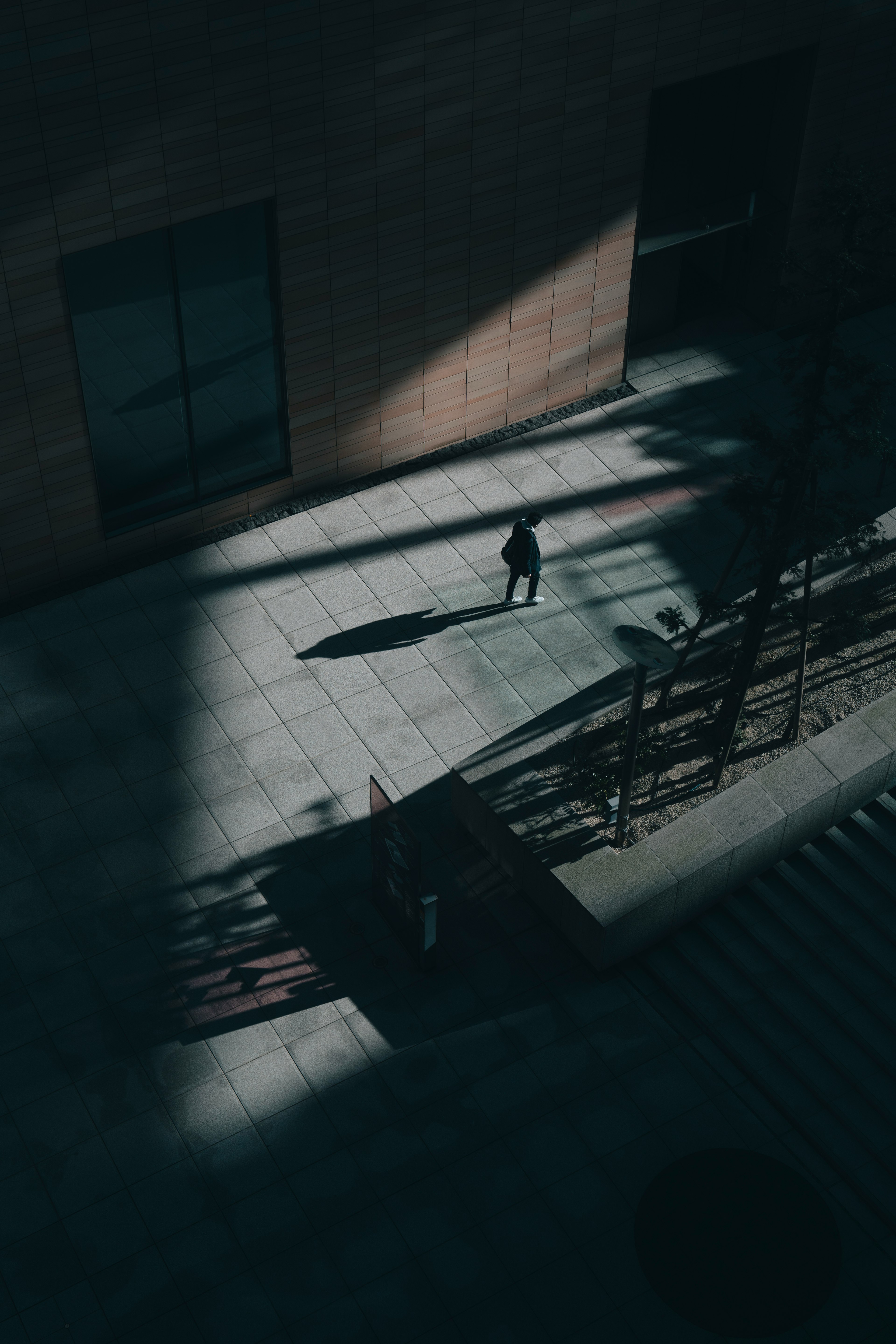 A person standing in shadows with geometric structures