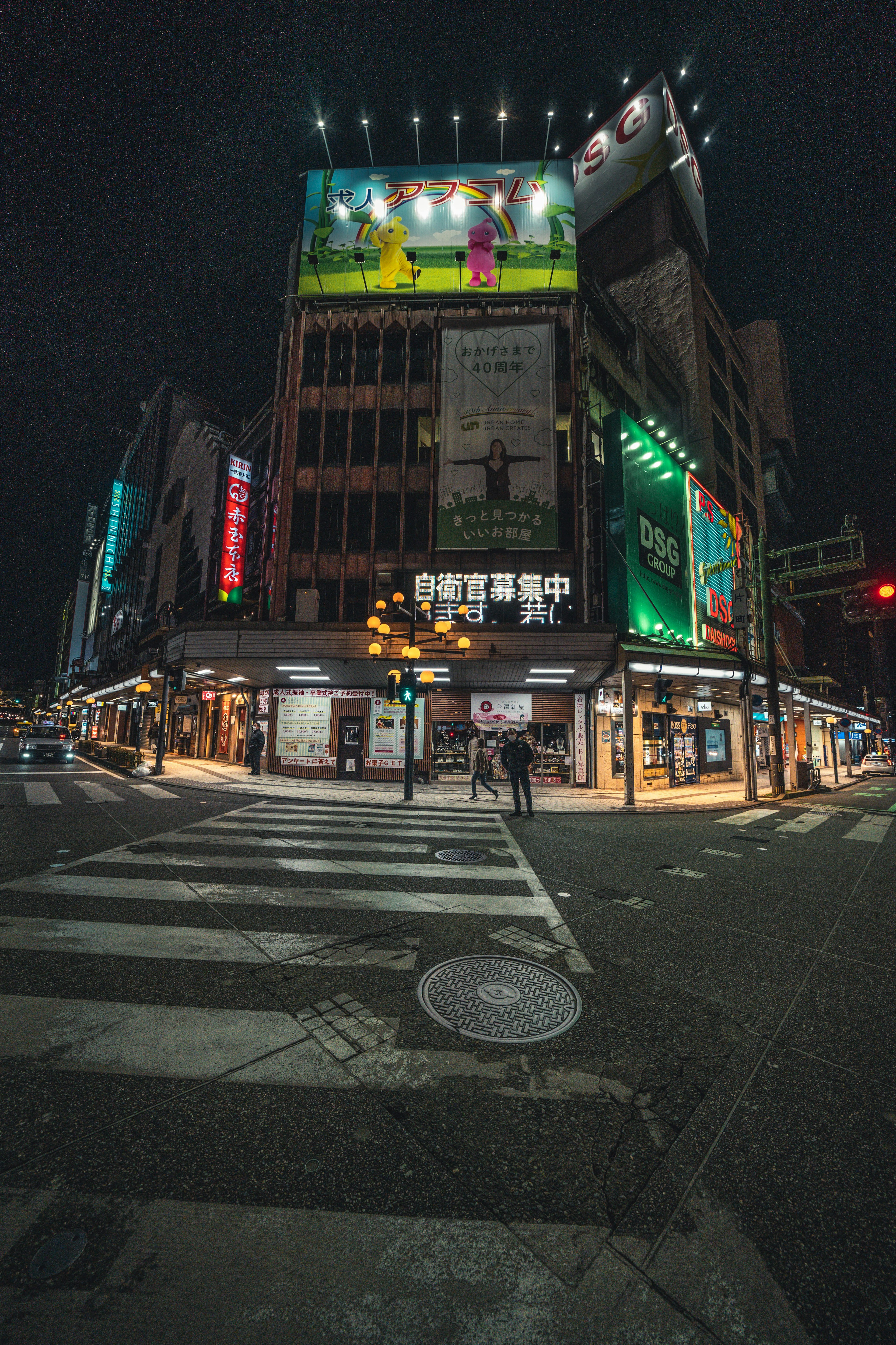 Edificio con carteles brillantes en una intersección nocturna