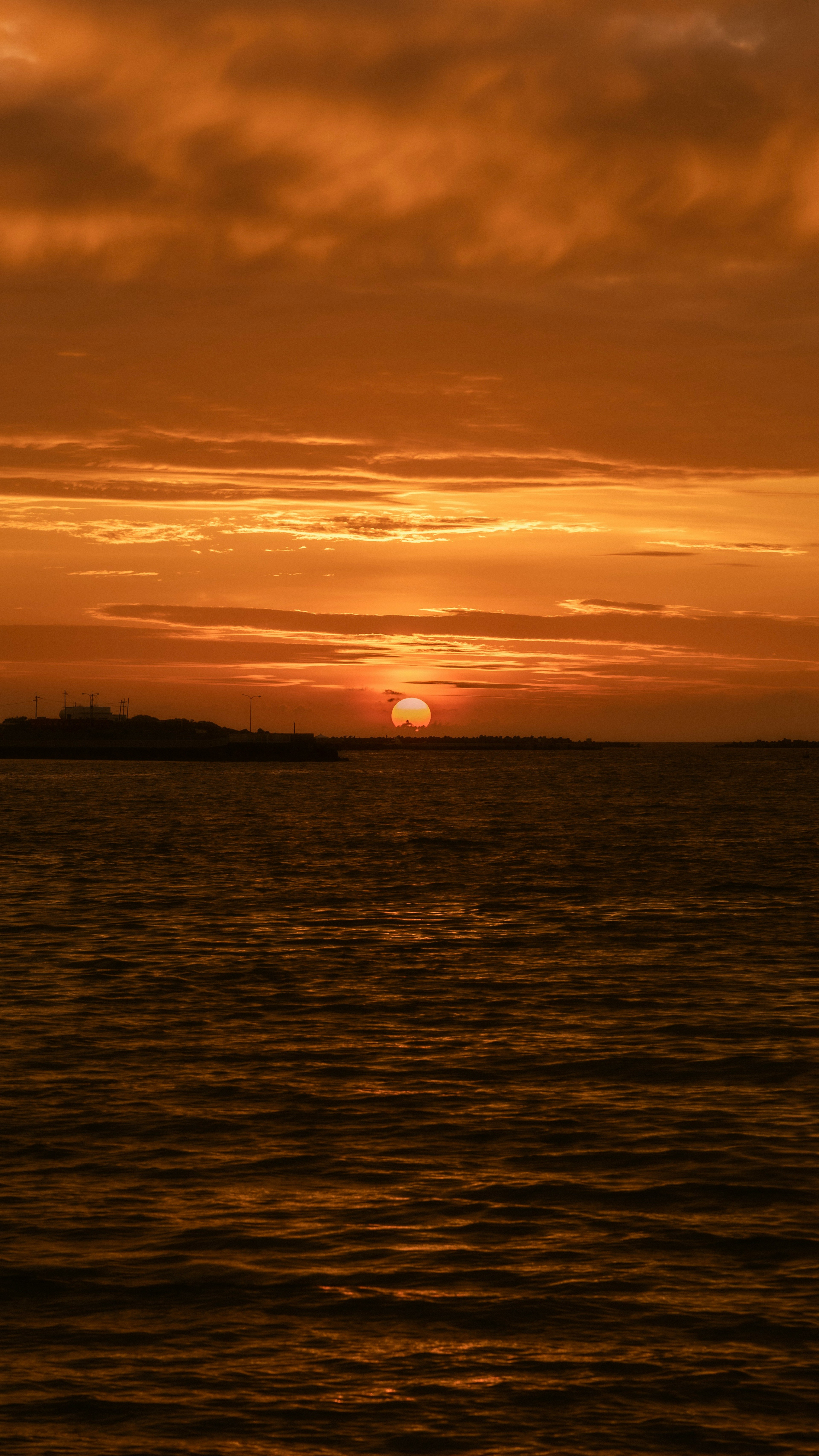 Szenischer Blick auf einen Sonnenuntergang über dem Ozean mit orangefarbenen Nuancen