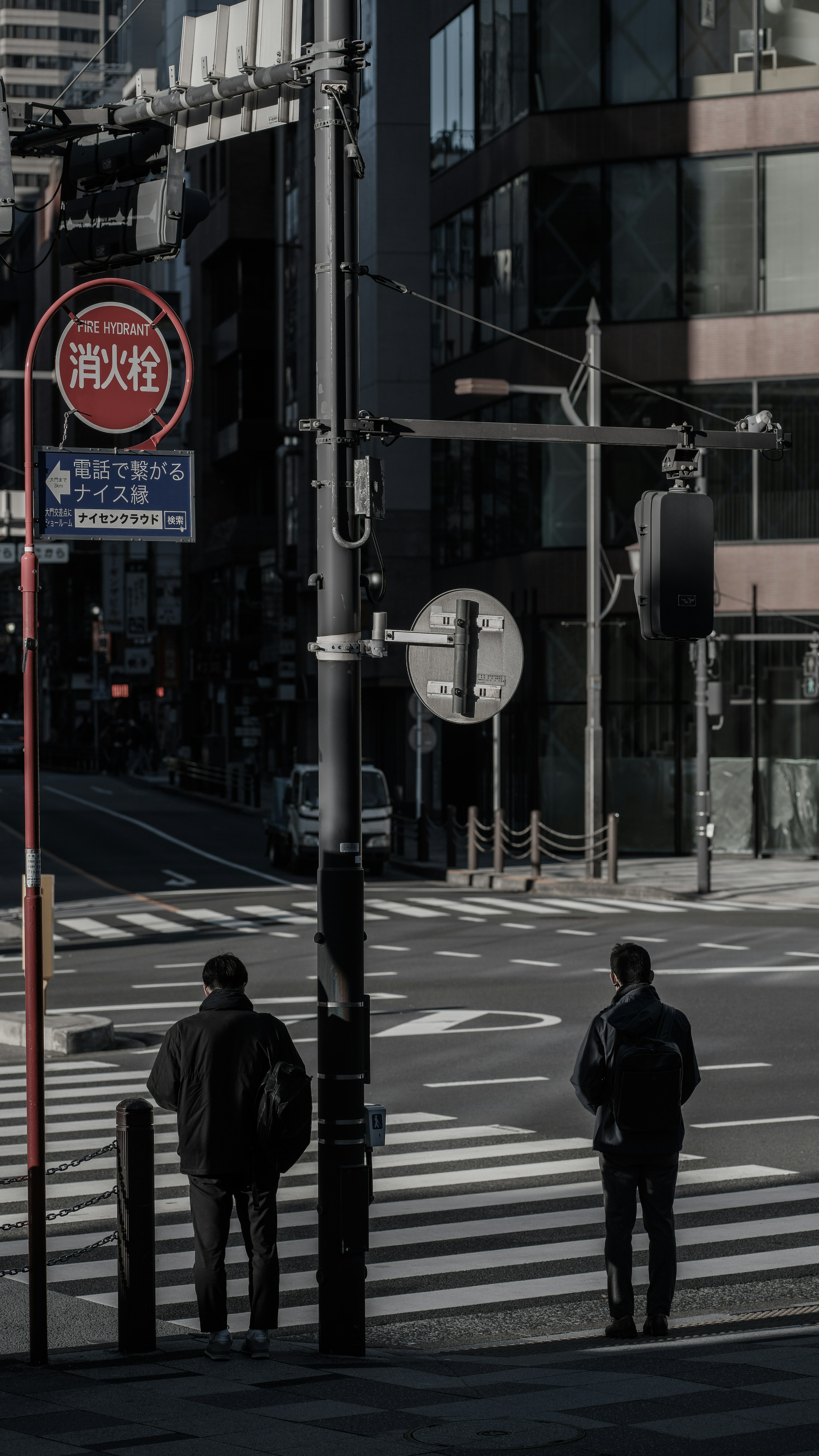 两名男子在城市人行横道上等待红绿灯