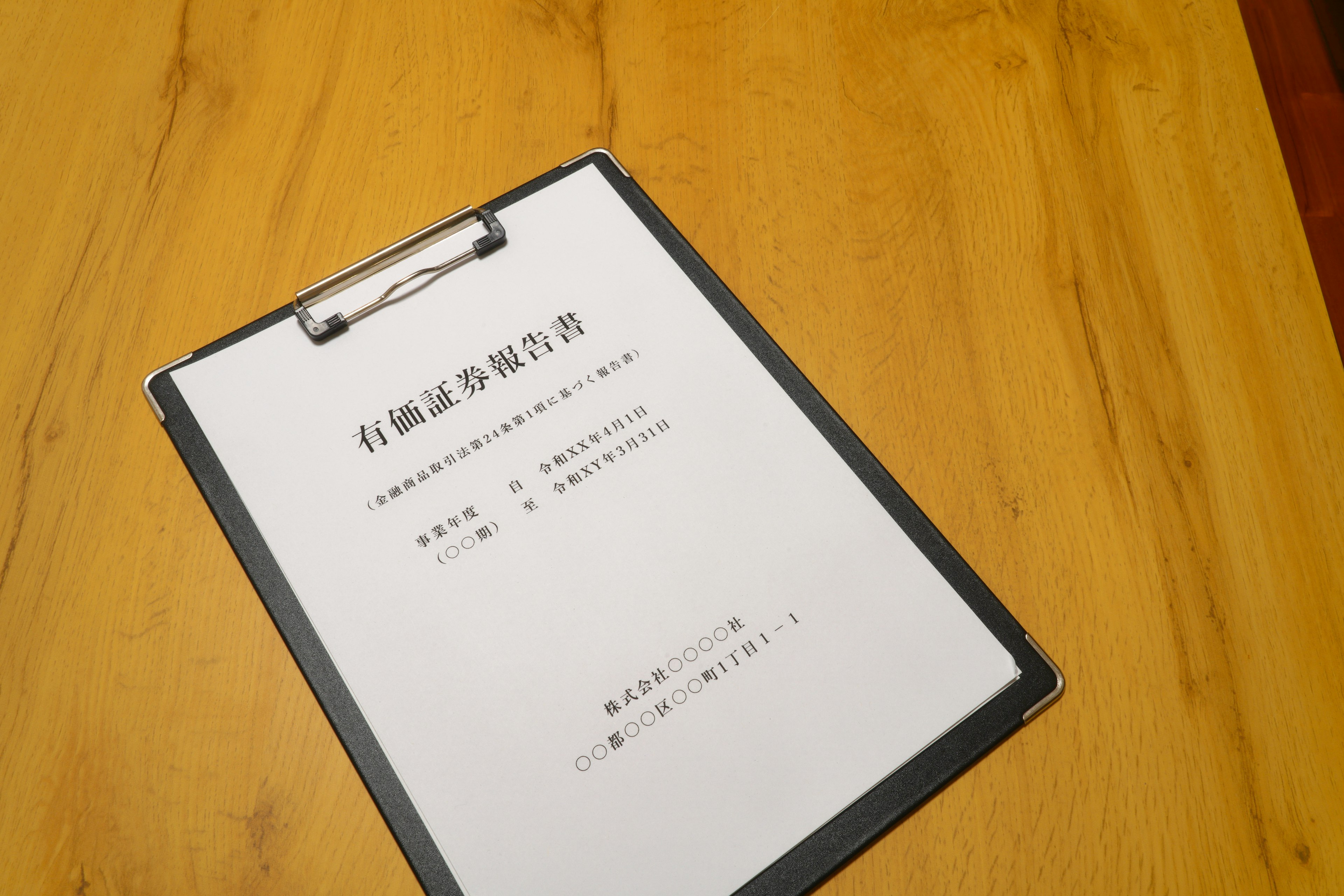 A clipboard with a document placed on a wooden table