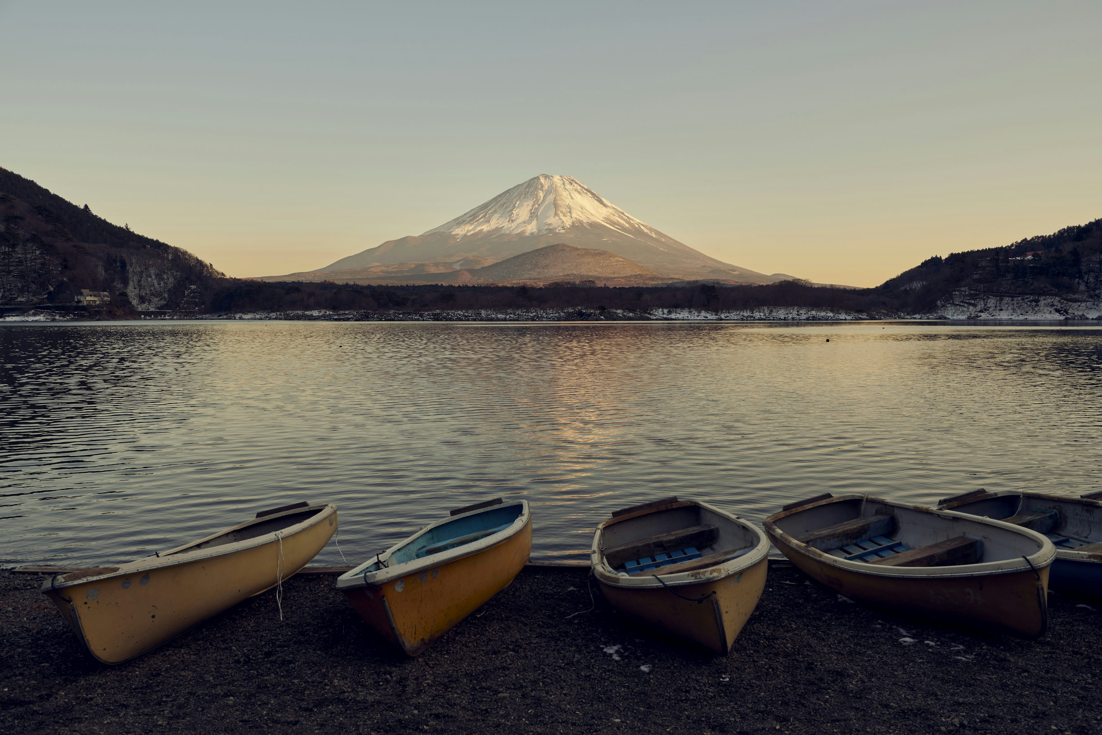 Malerscher Blick auf den Fuji mit kleinen Booten am ruhigen See