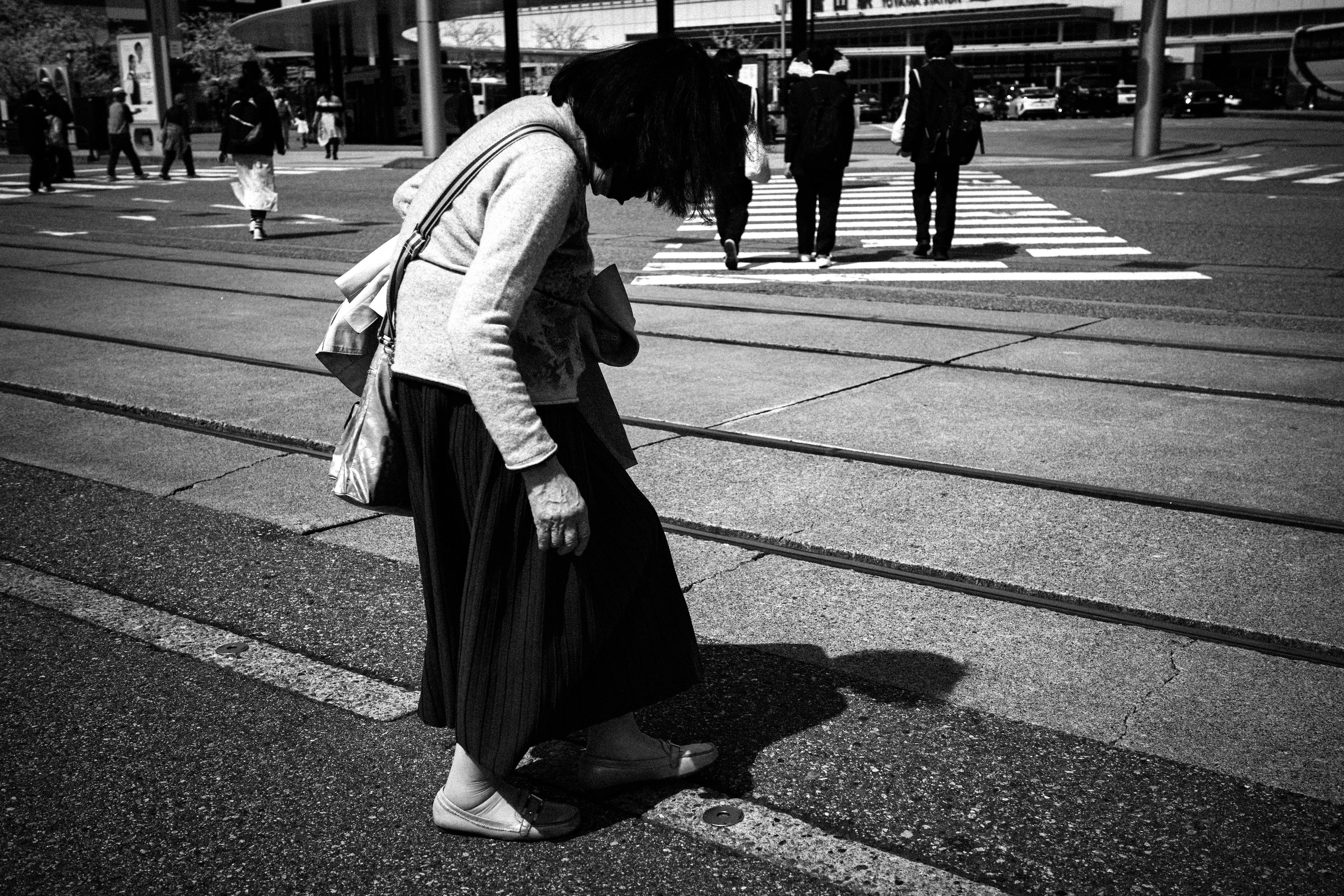 Una donna che guarda a terra mentre è scalza in una foto in bianco e nero