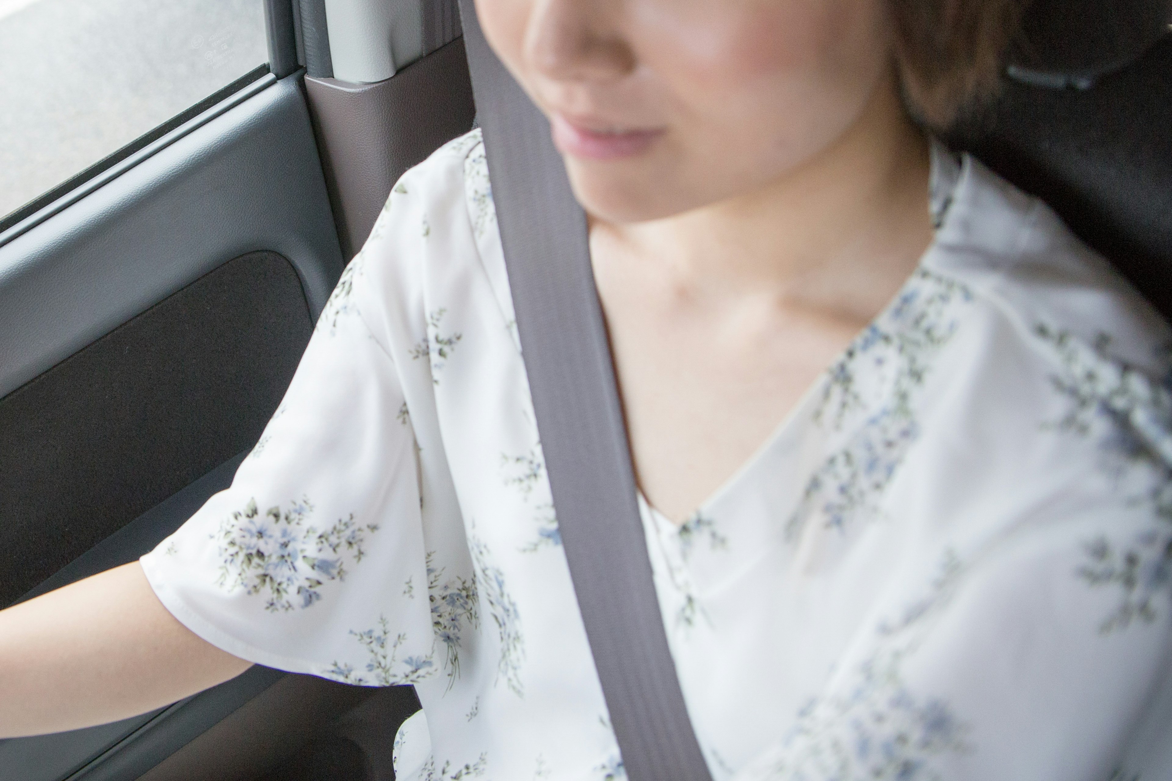 A woman in a car wearing a seatbelt