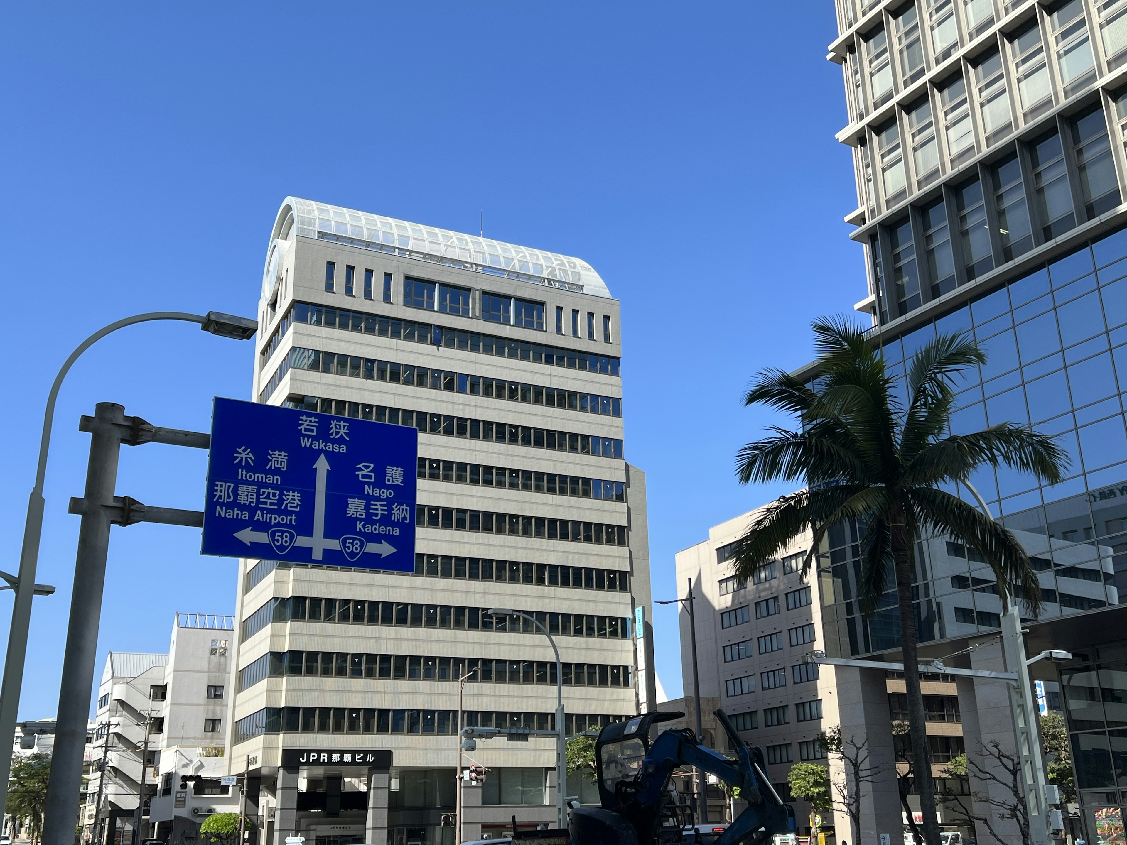 高層ビルと青空の風景、街路標識が見える